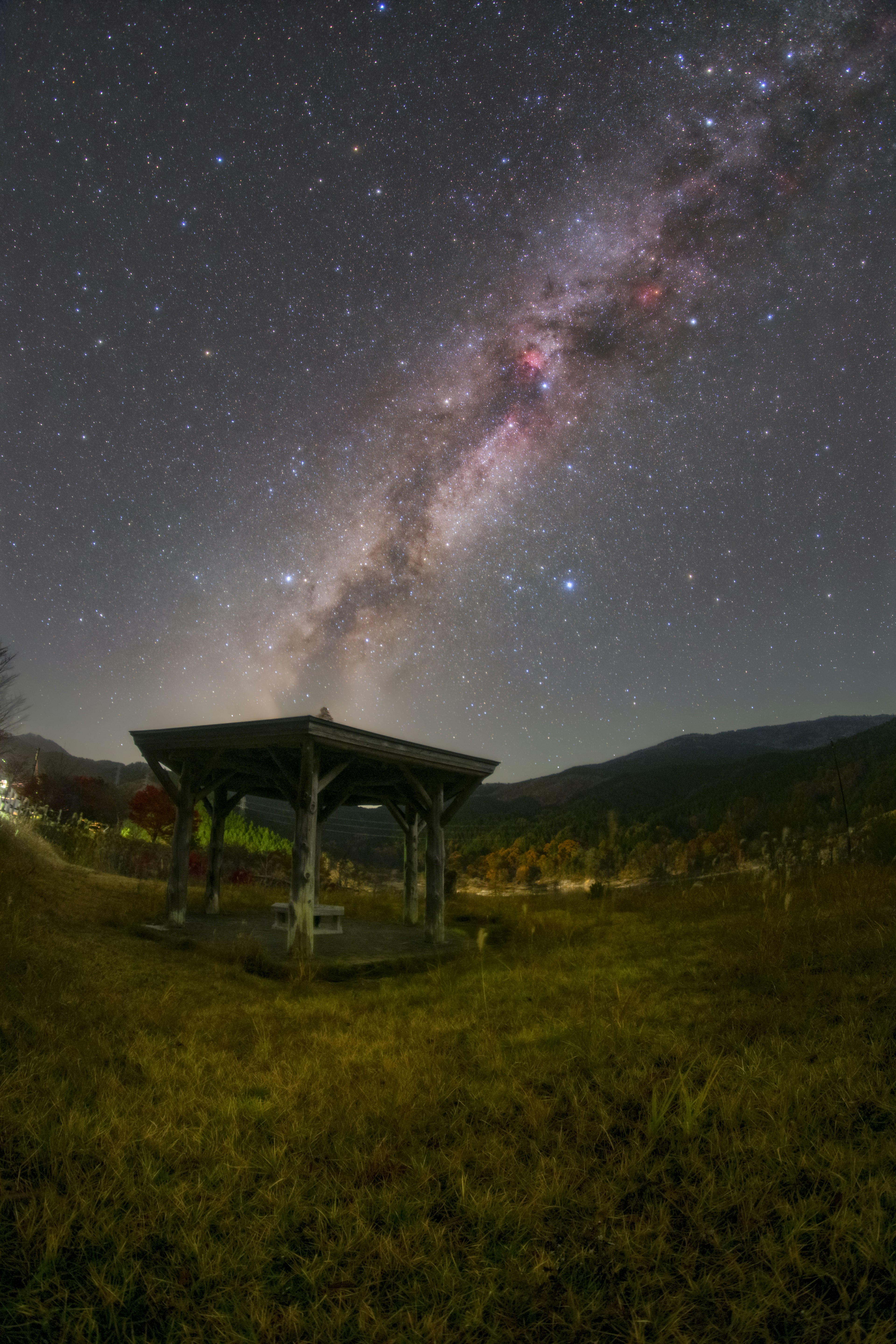 星空の下にある小屋と天の川の壮大な景色