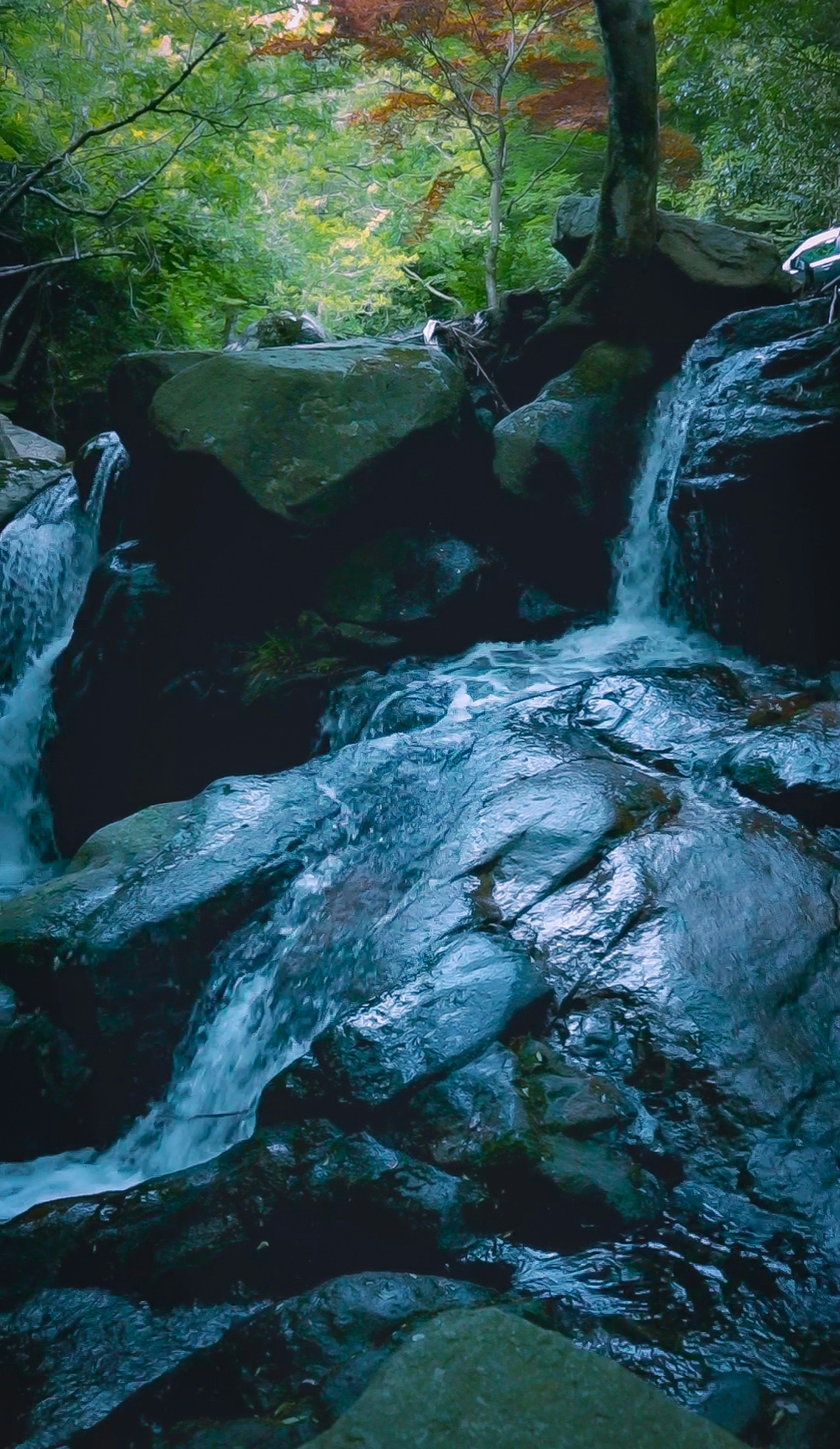 Ruhige Wasserfall-Szene mit blauem Wasser, das über Felsen fließt