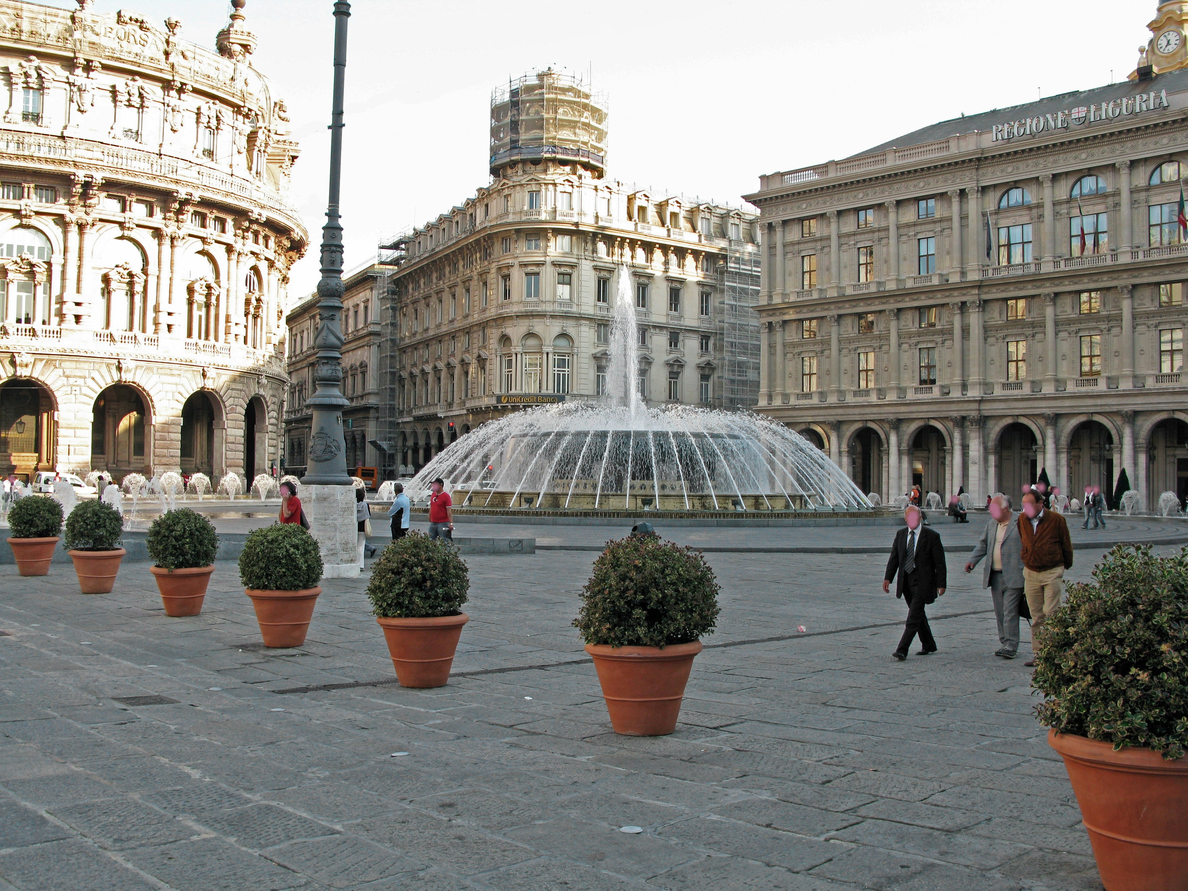 Una piazza pittoresca con una fontana e persone che camminano