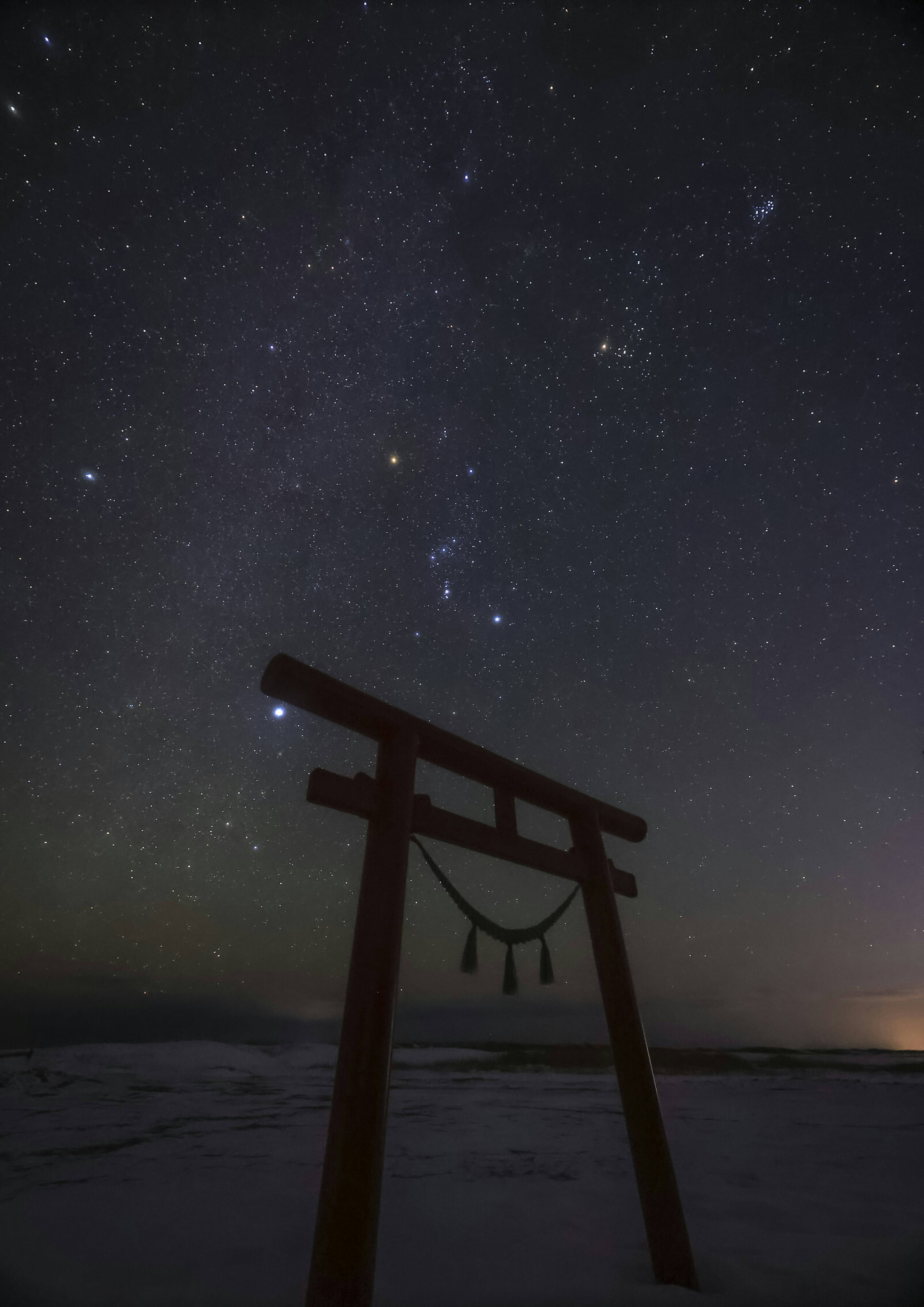 夜空に浮かぶ鳥居と星々のコントラスト