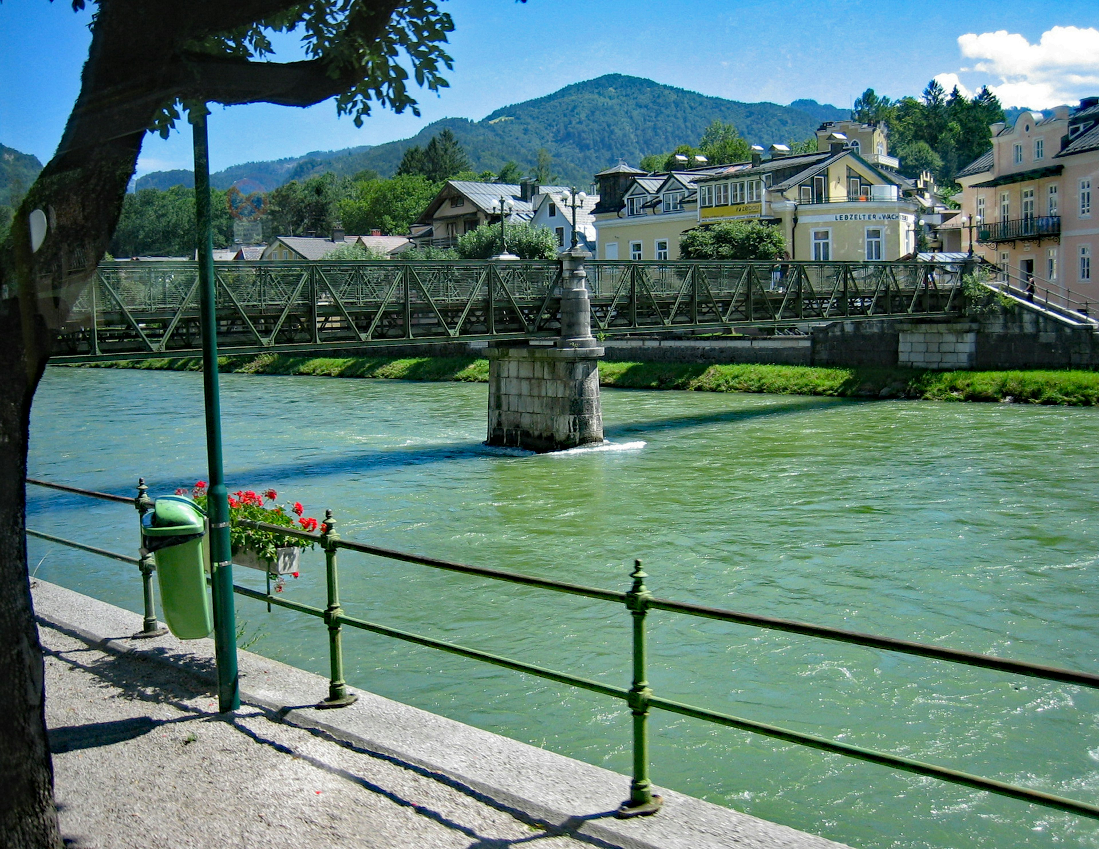 Vista pintoresca de un río azul con un puente edificios coloridos y montañas