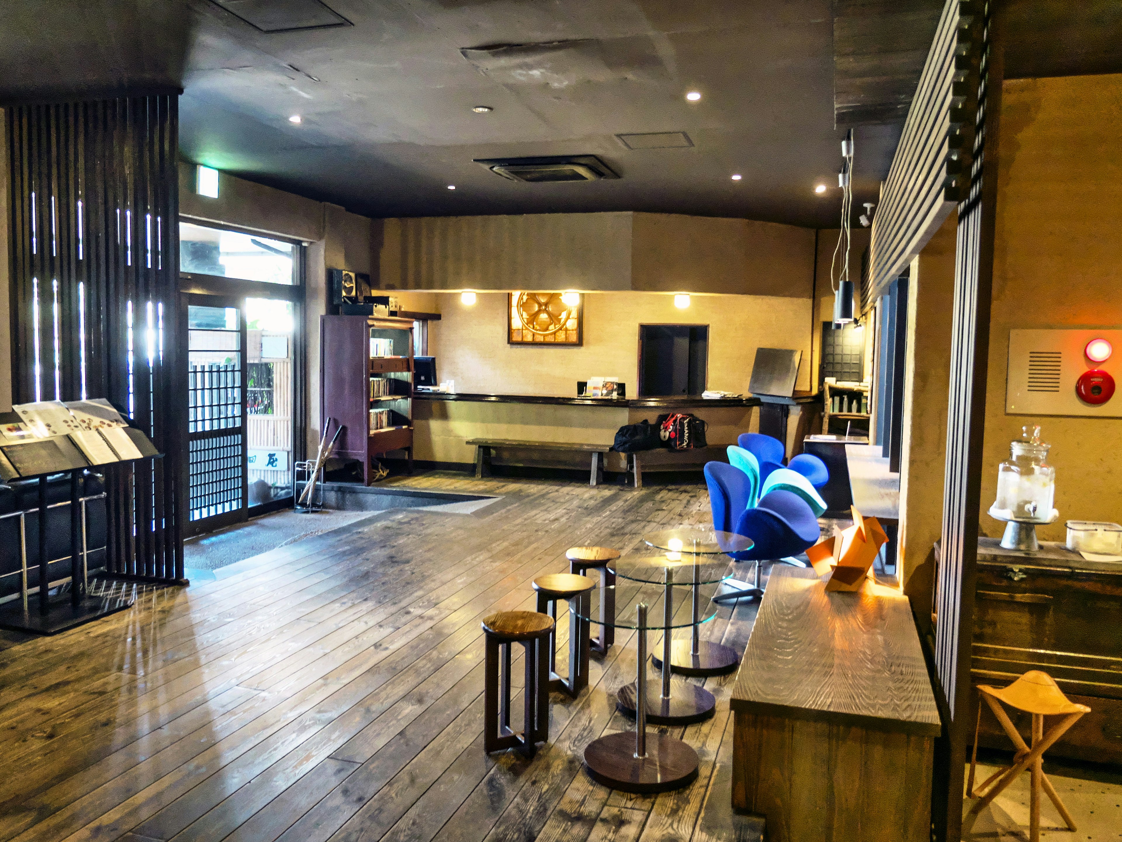 Interior moderno y sereno de una cafetería con suelos de madera y muebles simples con sillas azules dispuestas