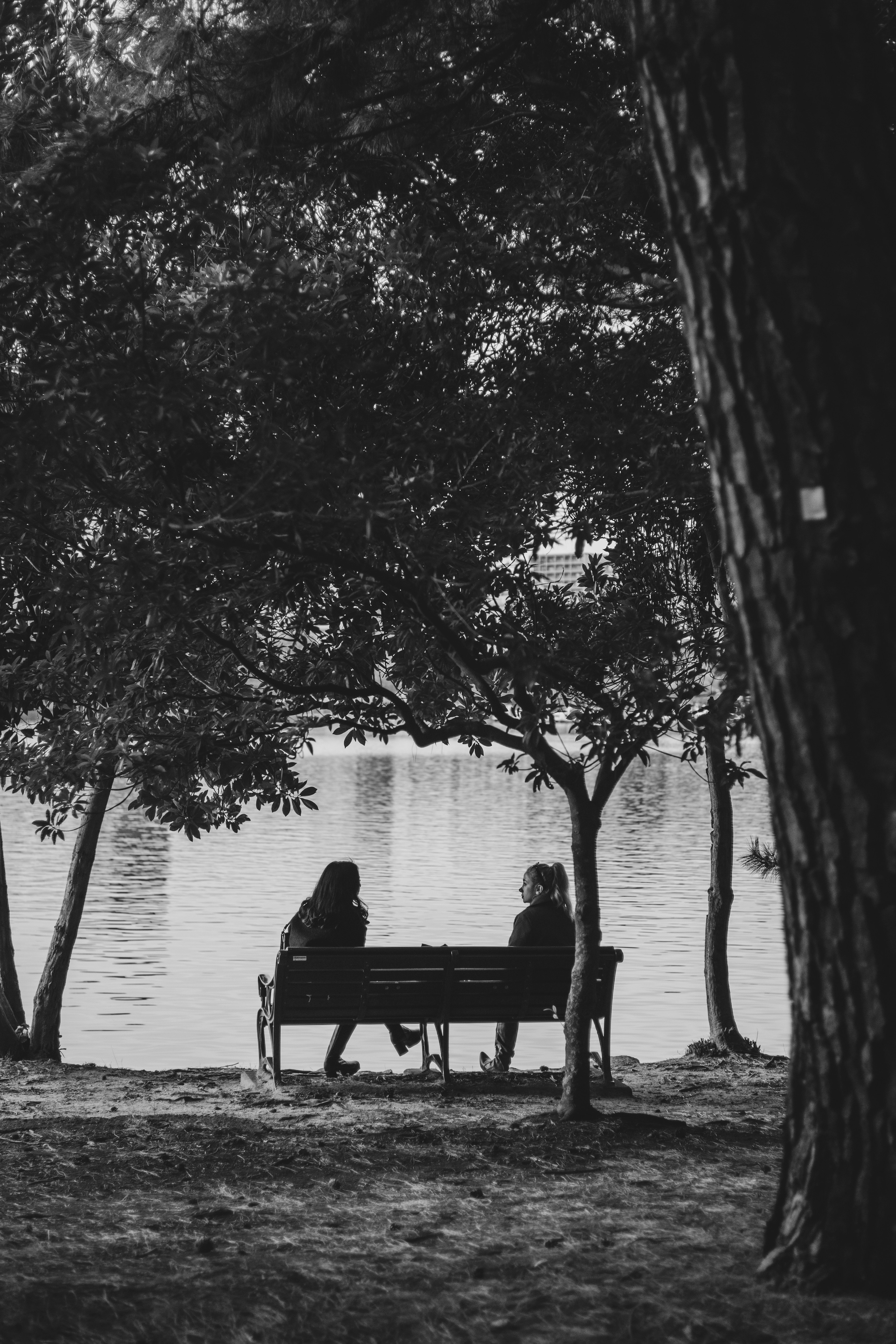 Deux personnes assises sur un banc au bord d'un lac tranquille