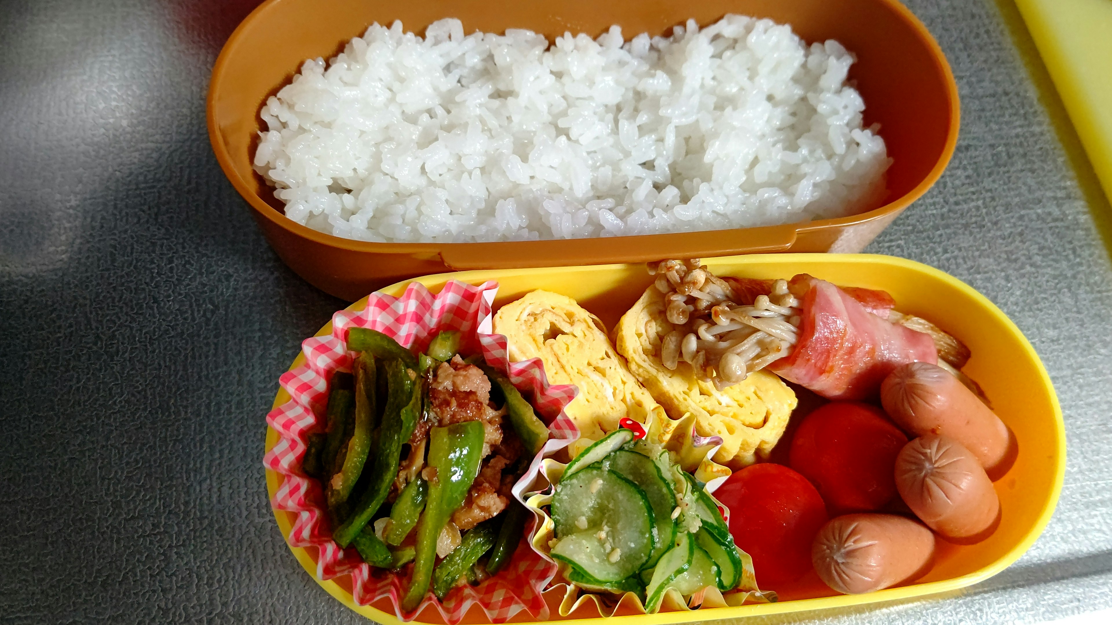 Bento box with white rice and an assortment of colorful dishes