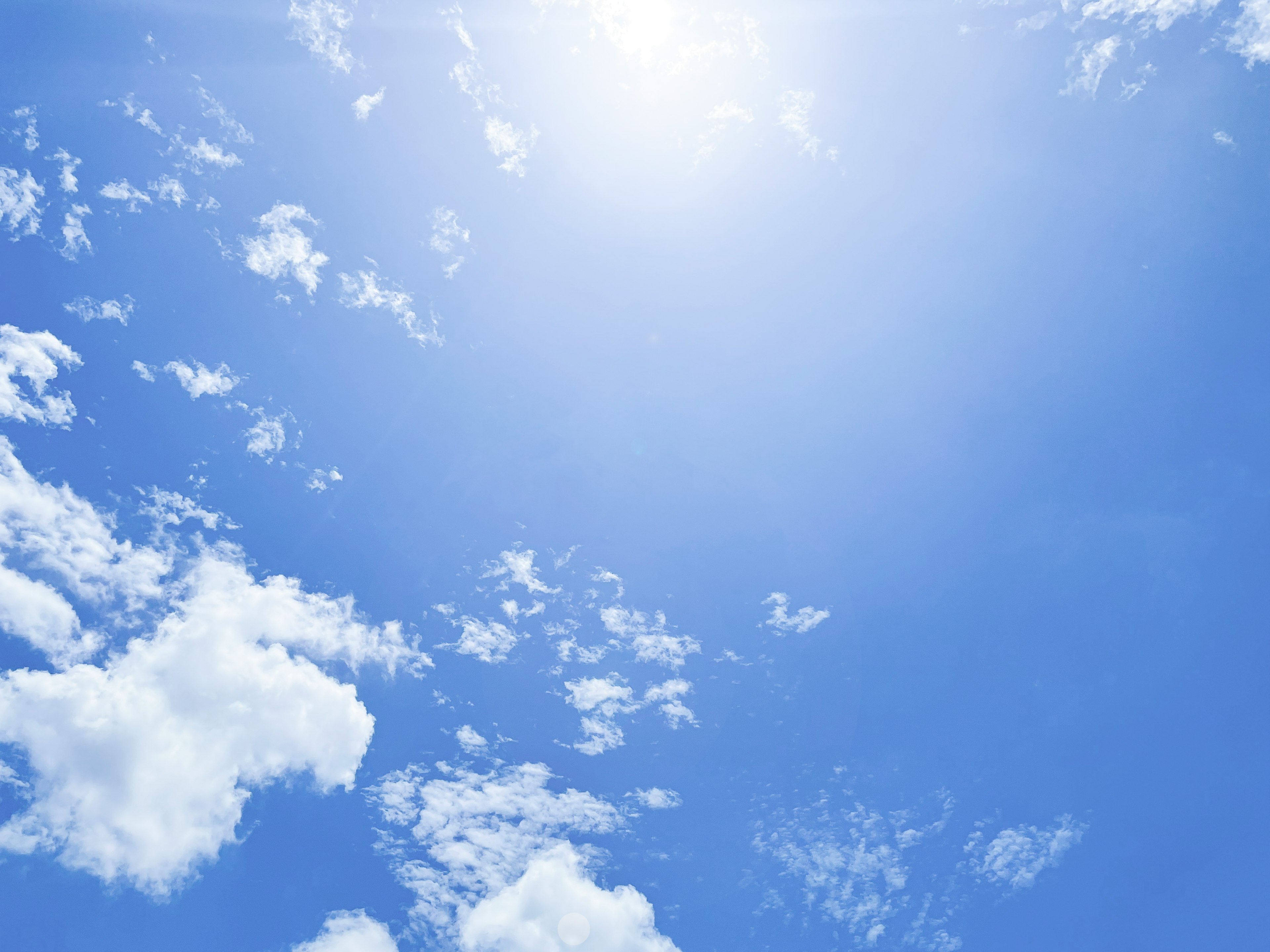 Ciel bleu lumineux avec des nuages blancs et de la lumière du soleil