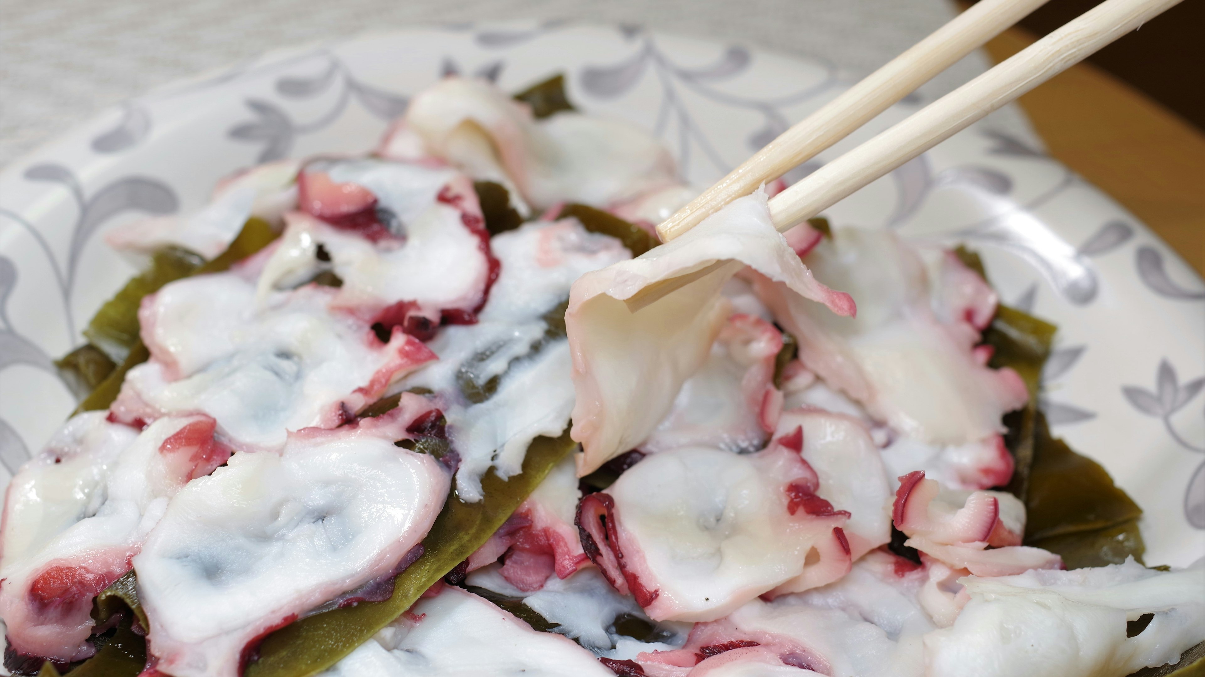 Plate of octopus sashimi with seaweed salad