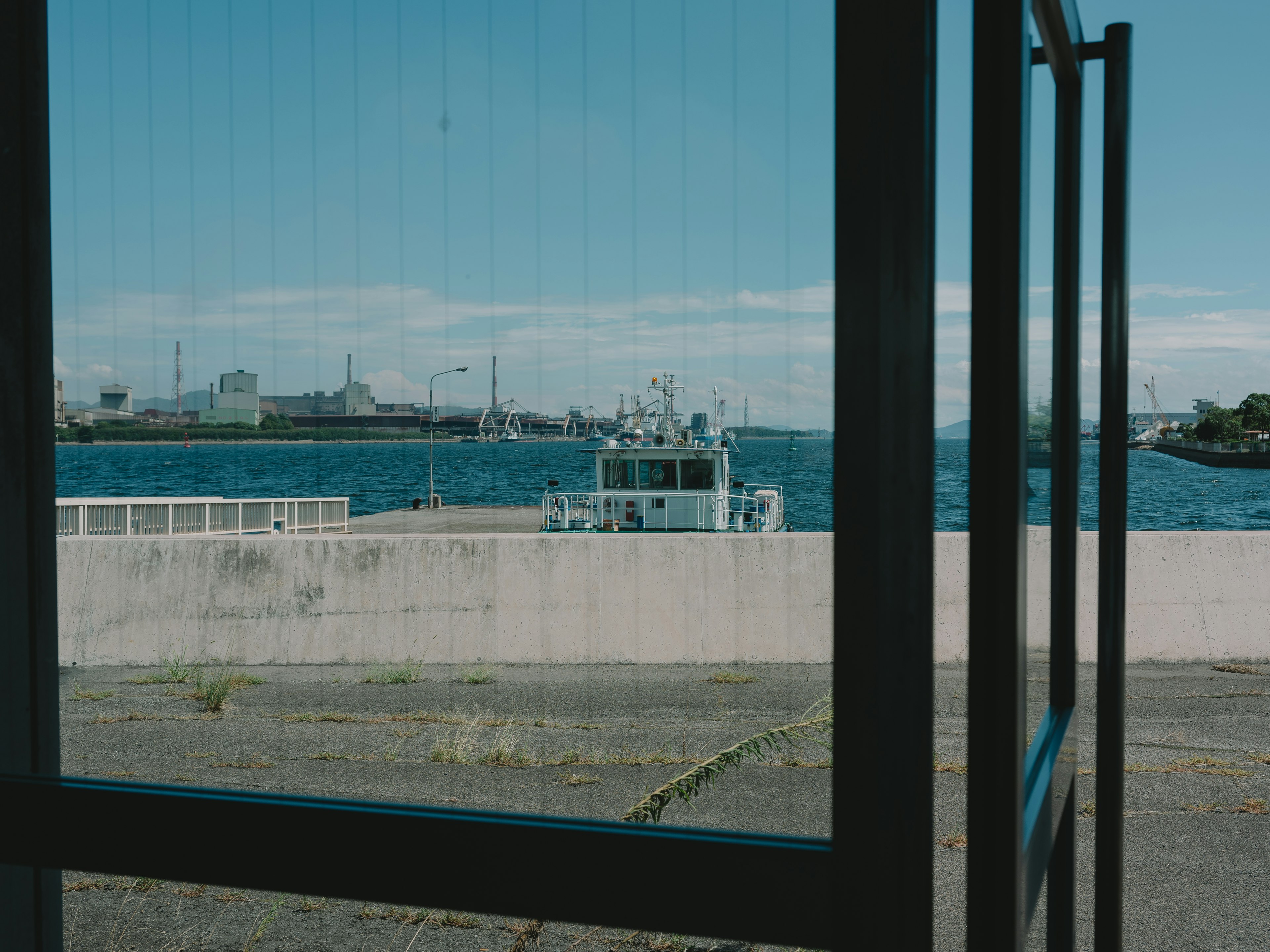 Vue de la mer bleue et d'un bateau à travers une fenêtre ouverte