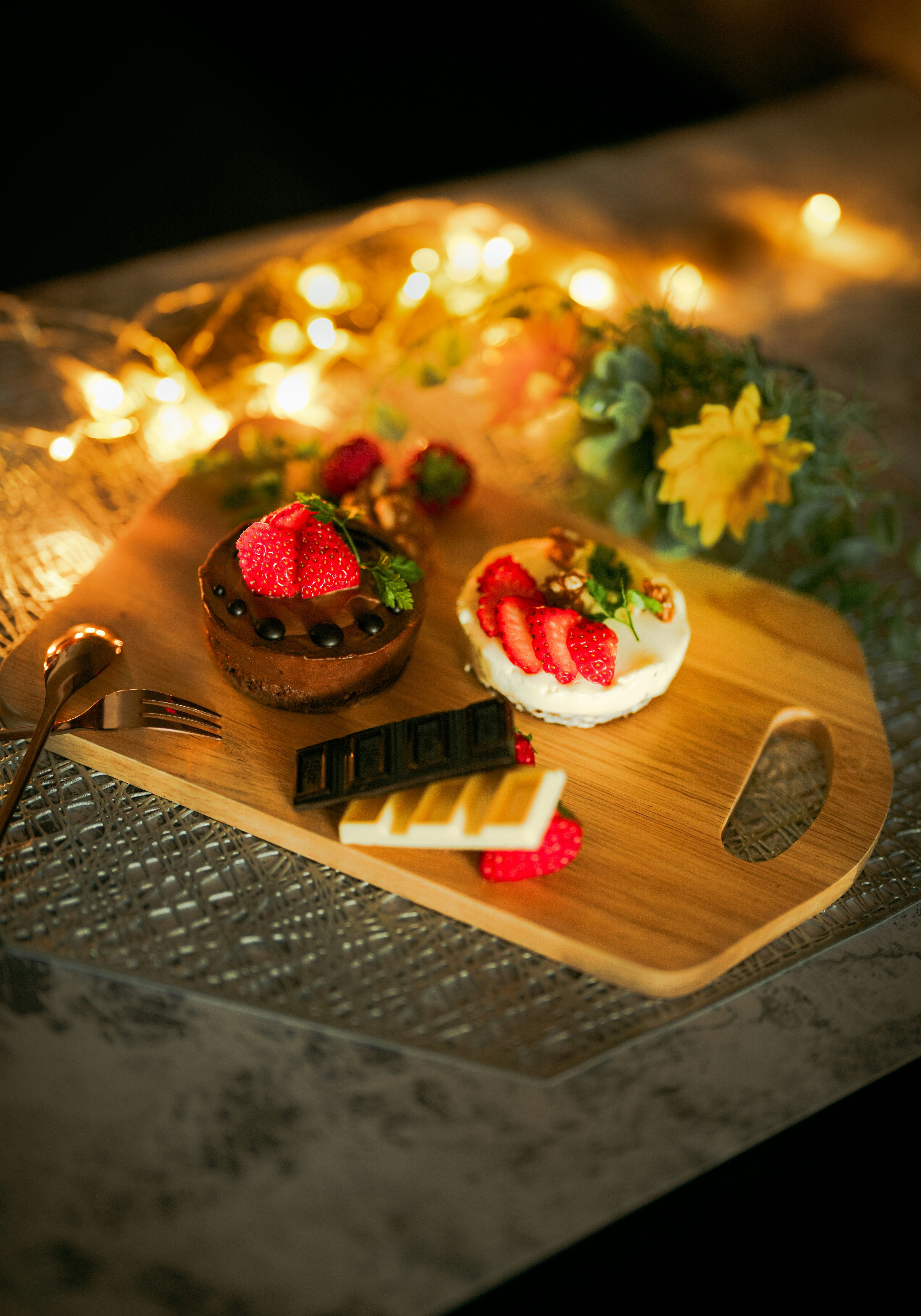 Elegantes Holztablett mit köstlichen Kuchen und Früchten schön arrangiert