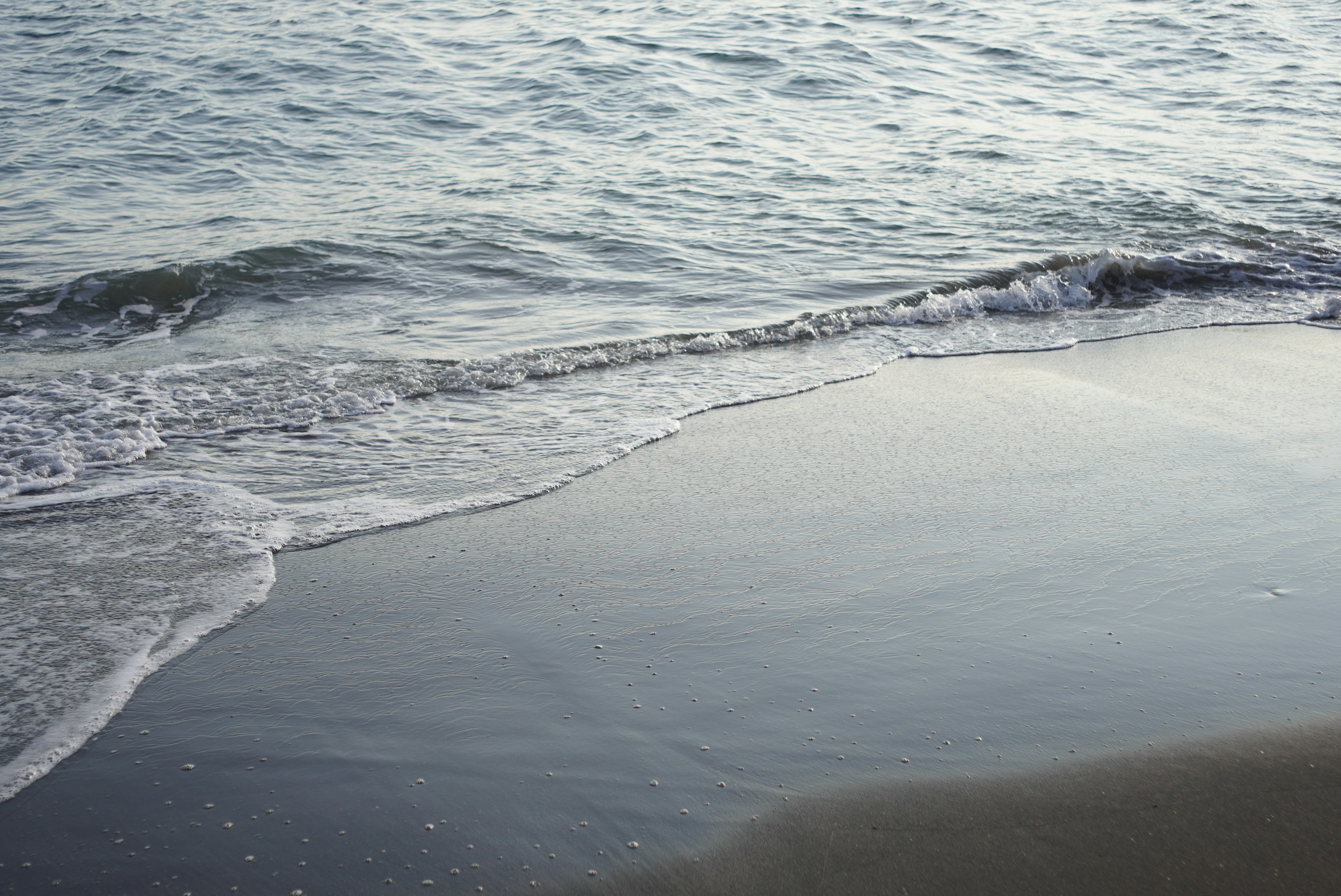 คลื่นสงบซัดชายหาดทราย