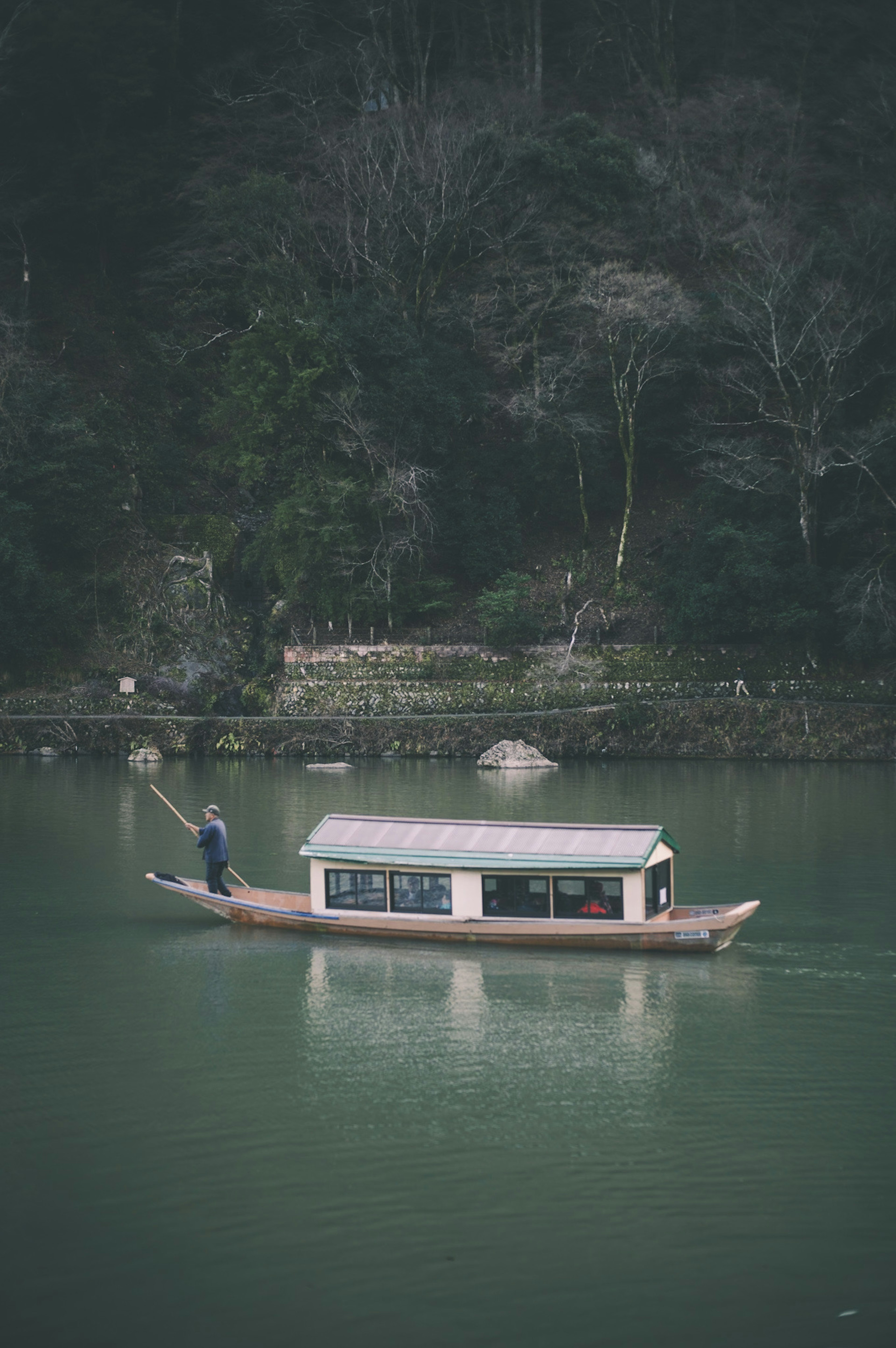 เรือไม้แบบดั้งเดิมที่มีชาวประมงอยู่ในทะเลสาบที่เงียบสงบ