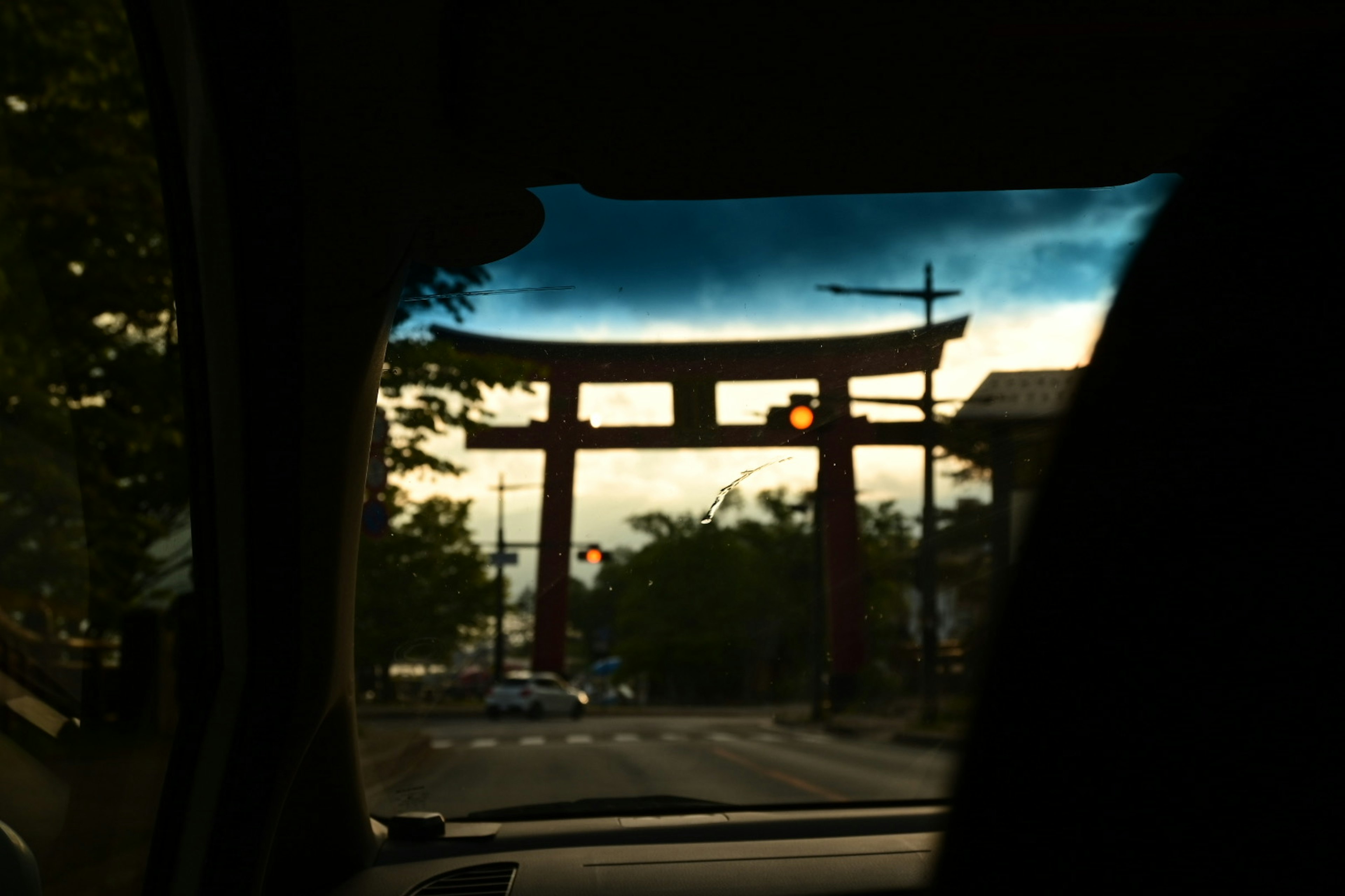 車の中から見た鳥居の景色夕暮れの空が背景