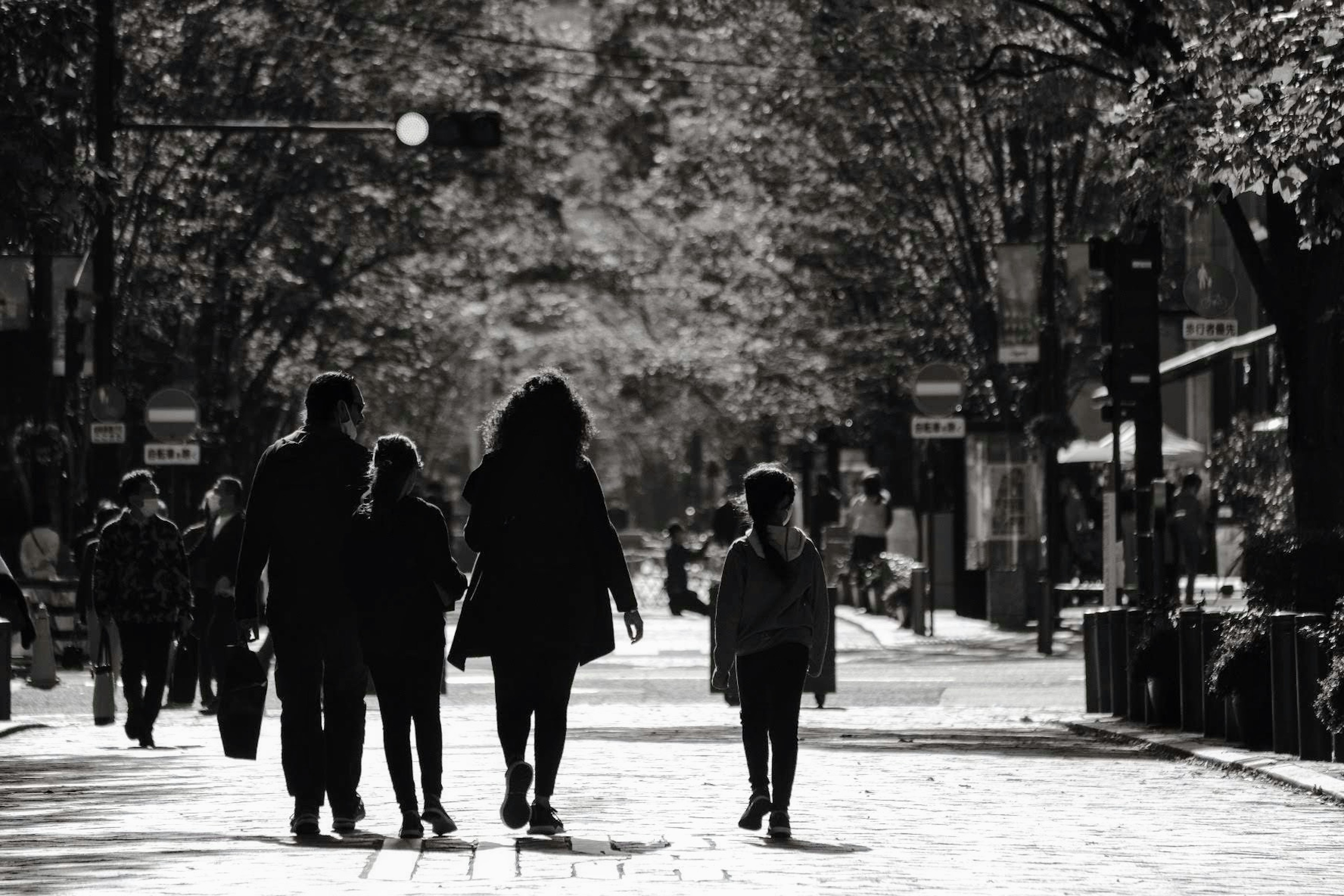 Silhouetten von Menschen, die auf einer monochromen Straße laufen