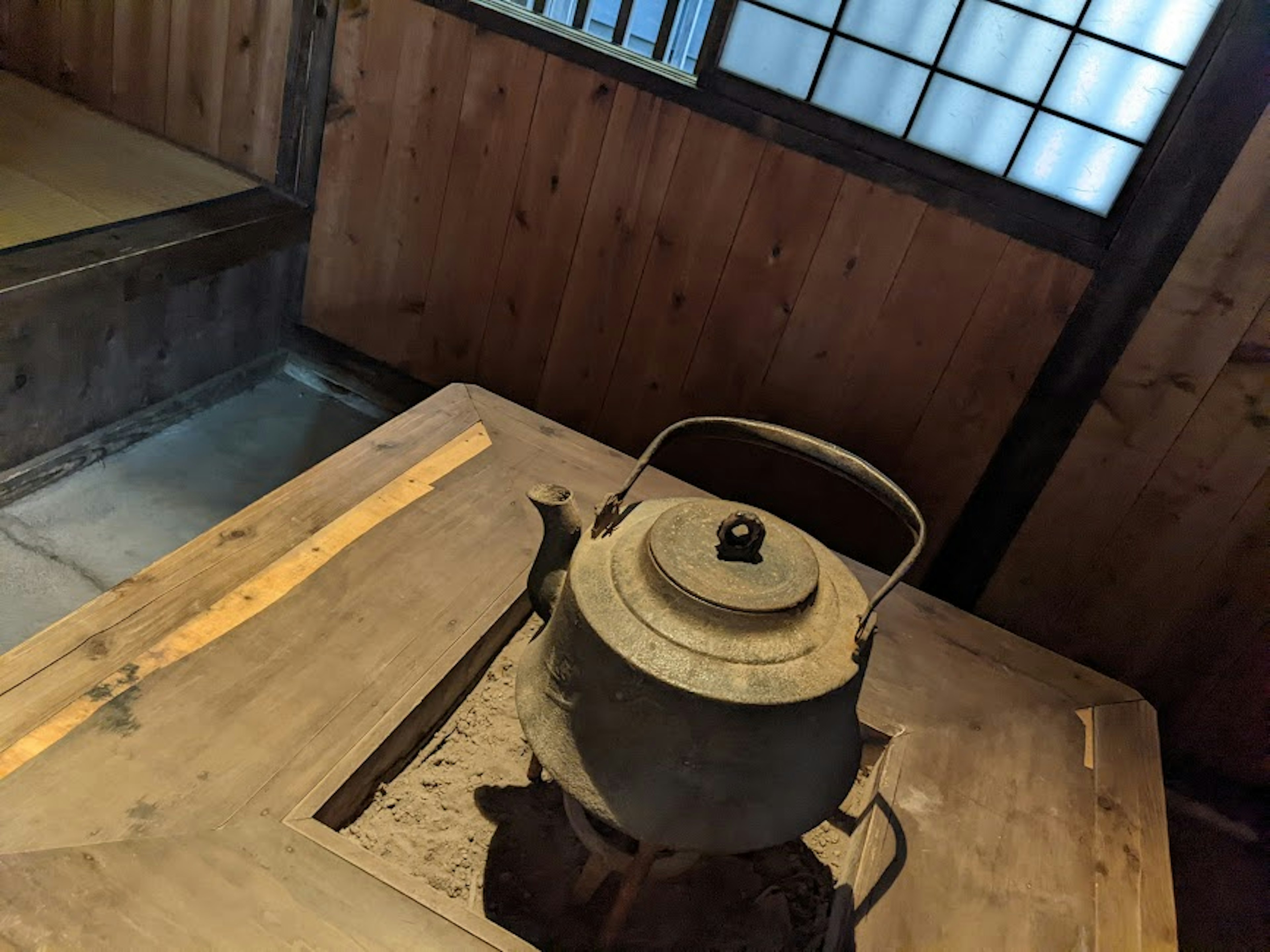 Interior de una casa japonesa tradicional con una tetera sobre una mesa de madera