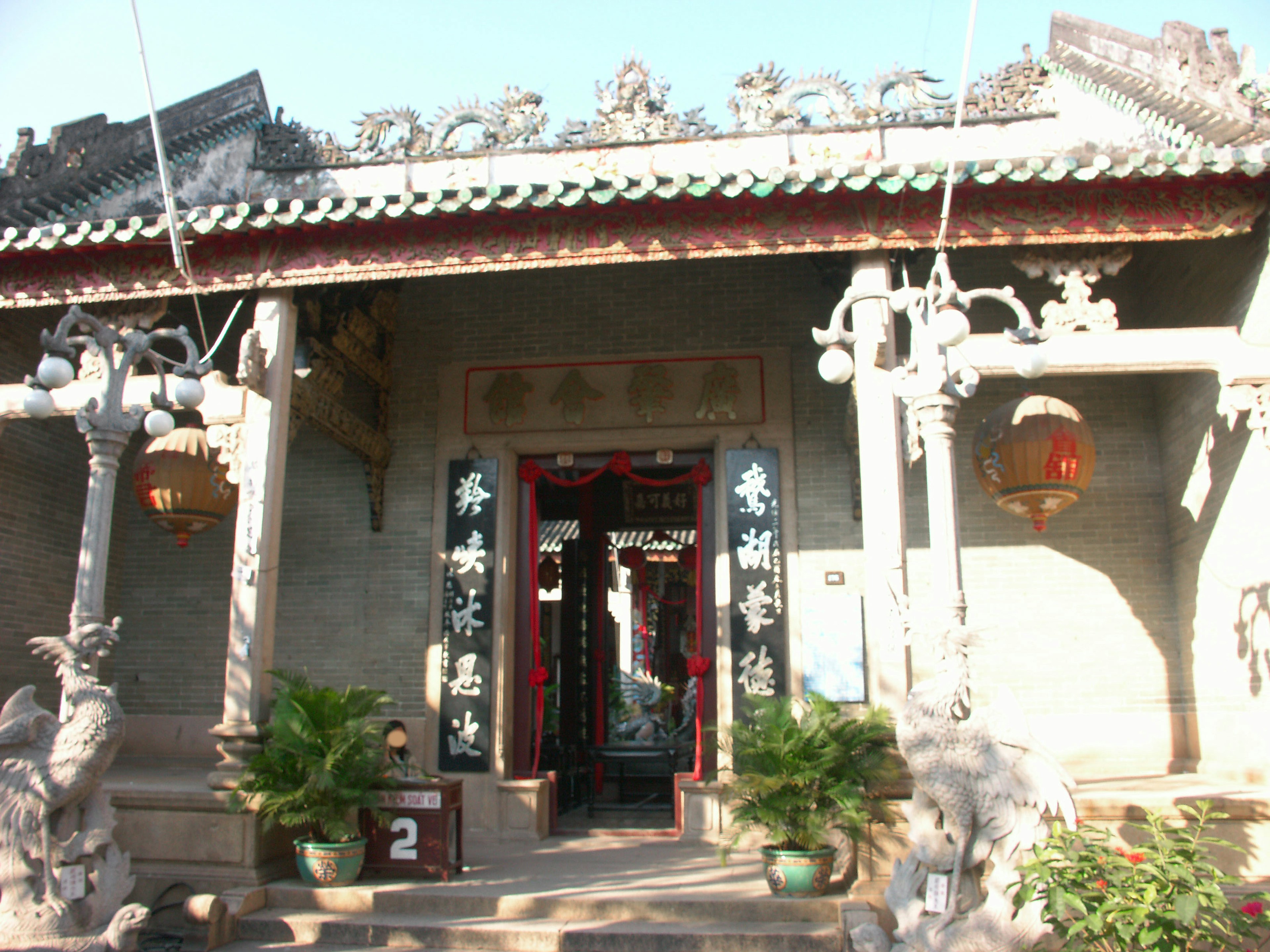 Entrada de un antiguo templo con esculturas decorativas y faroles