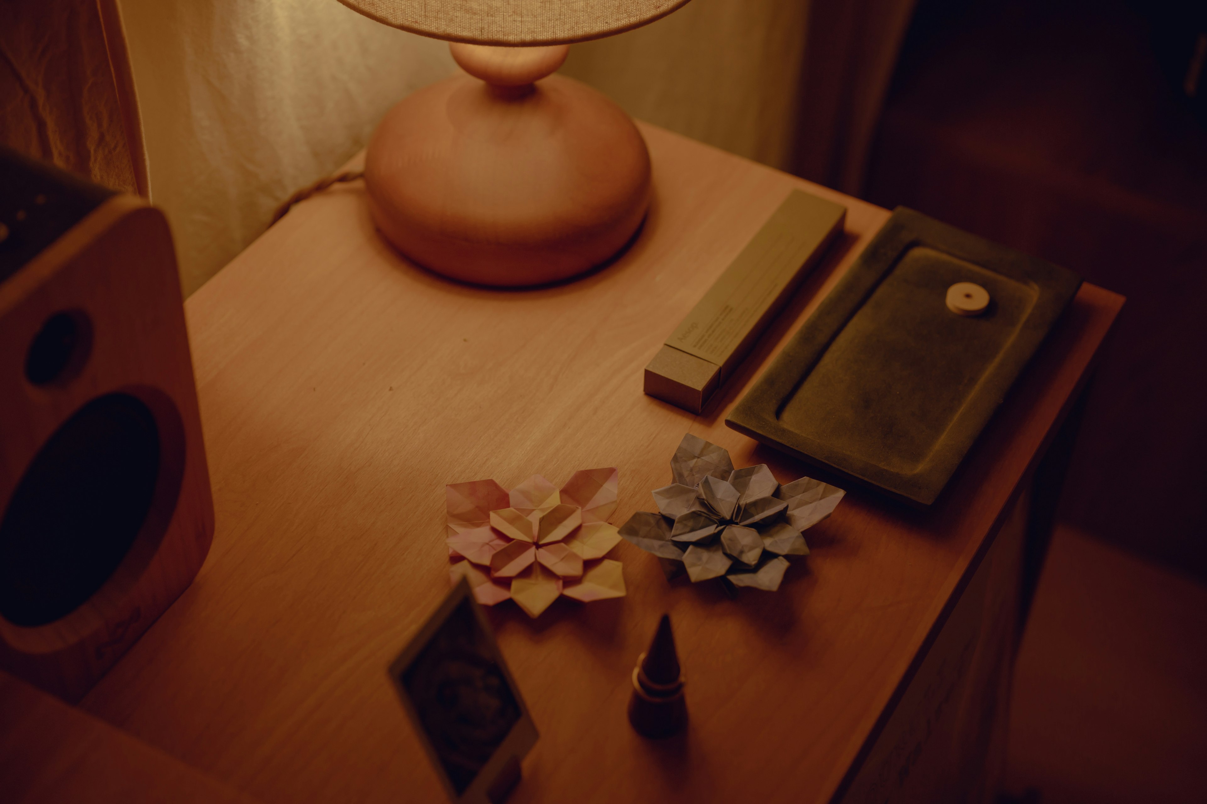 Una lámpara y objetos florales decorativos sobre una mesa de madera