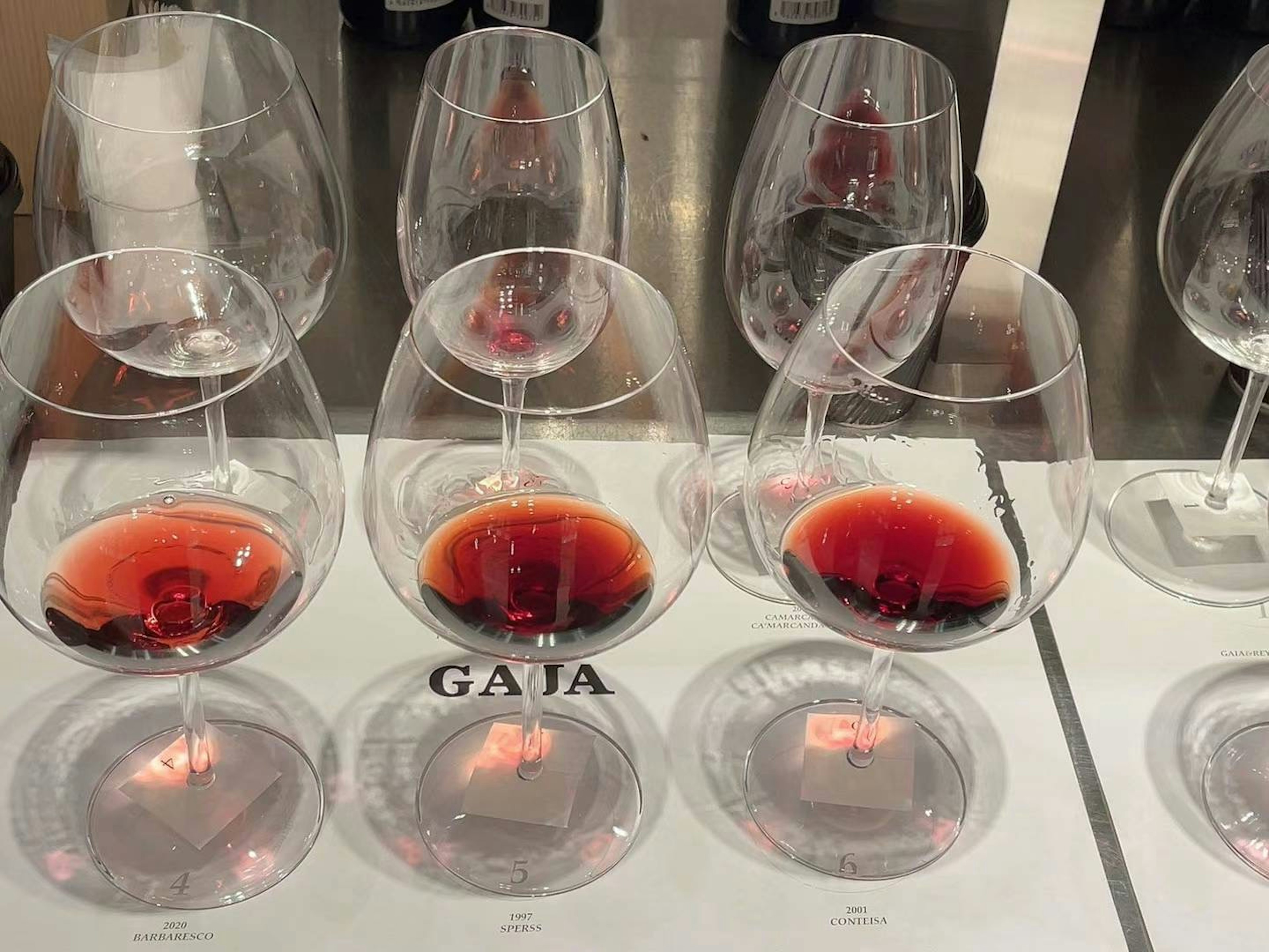 Une rangée de verres à vin remplis de vin rouge sur une table