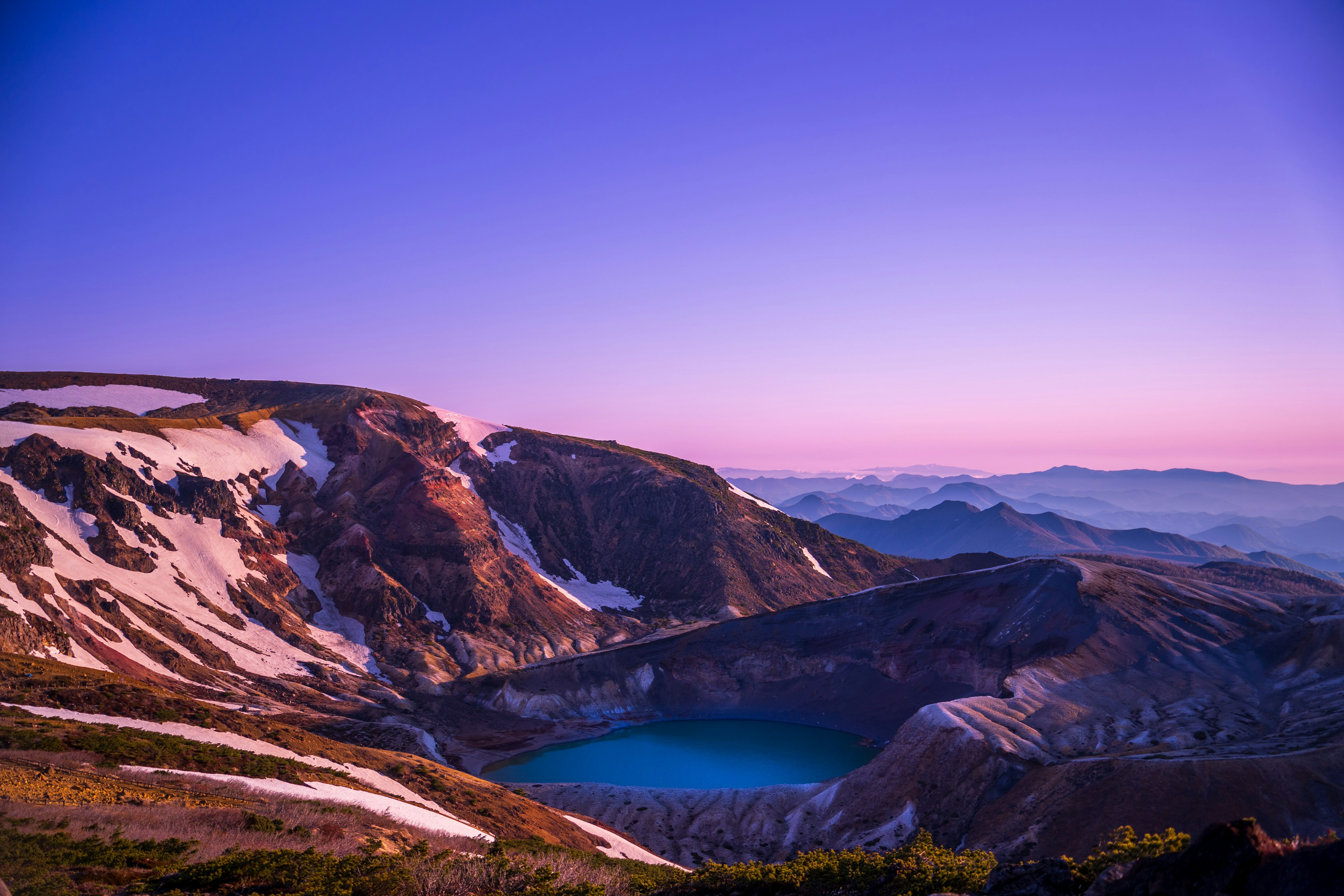 Pemandangan gunung yang indah dengan danau kawah biru saat senja