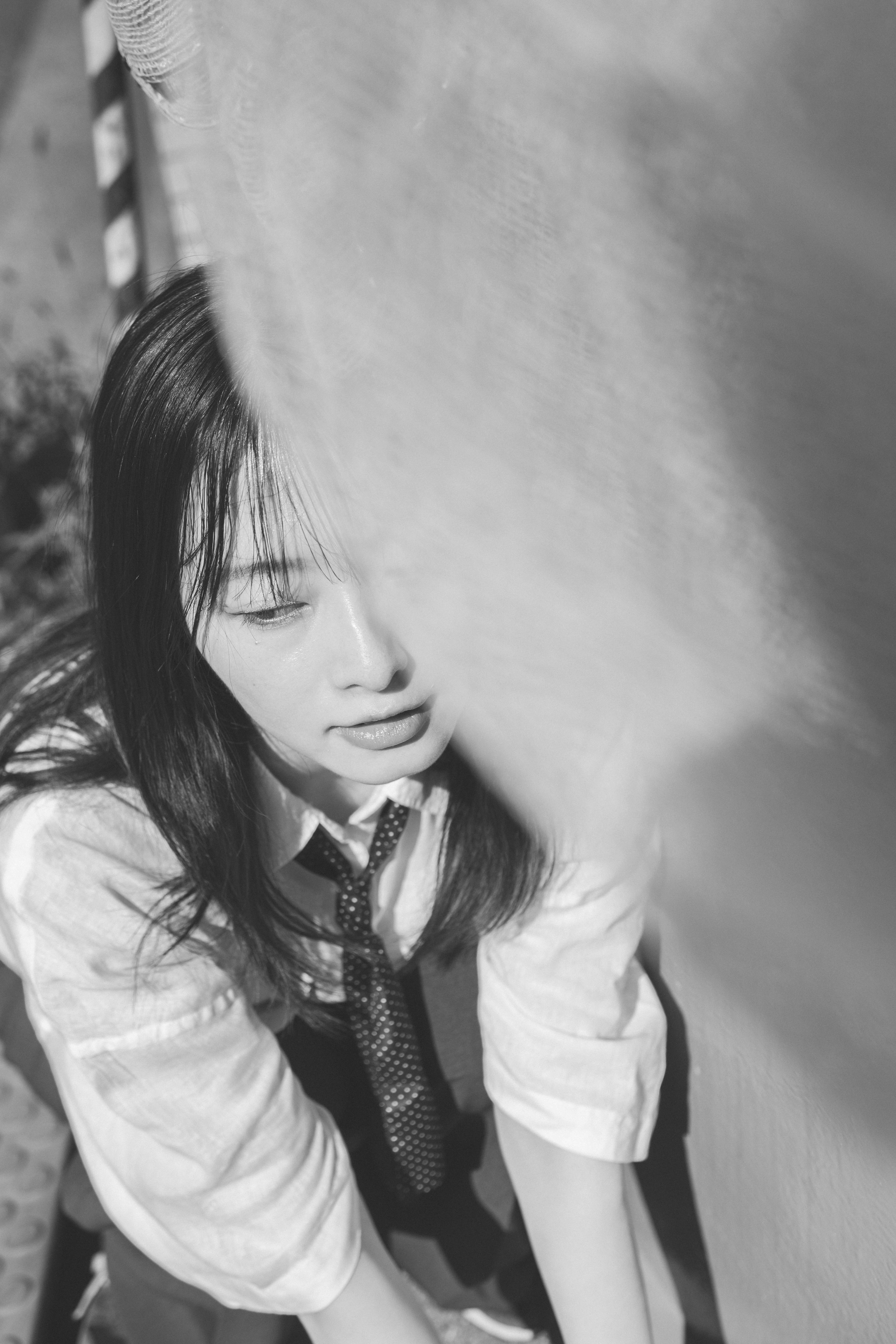 Portrait en noir et blanc d'une jeune femme en uniforme regardant l'objectif