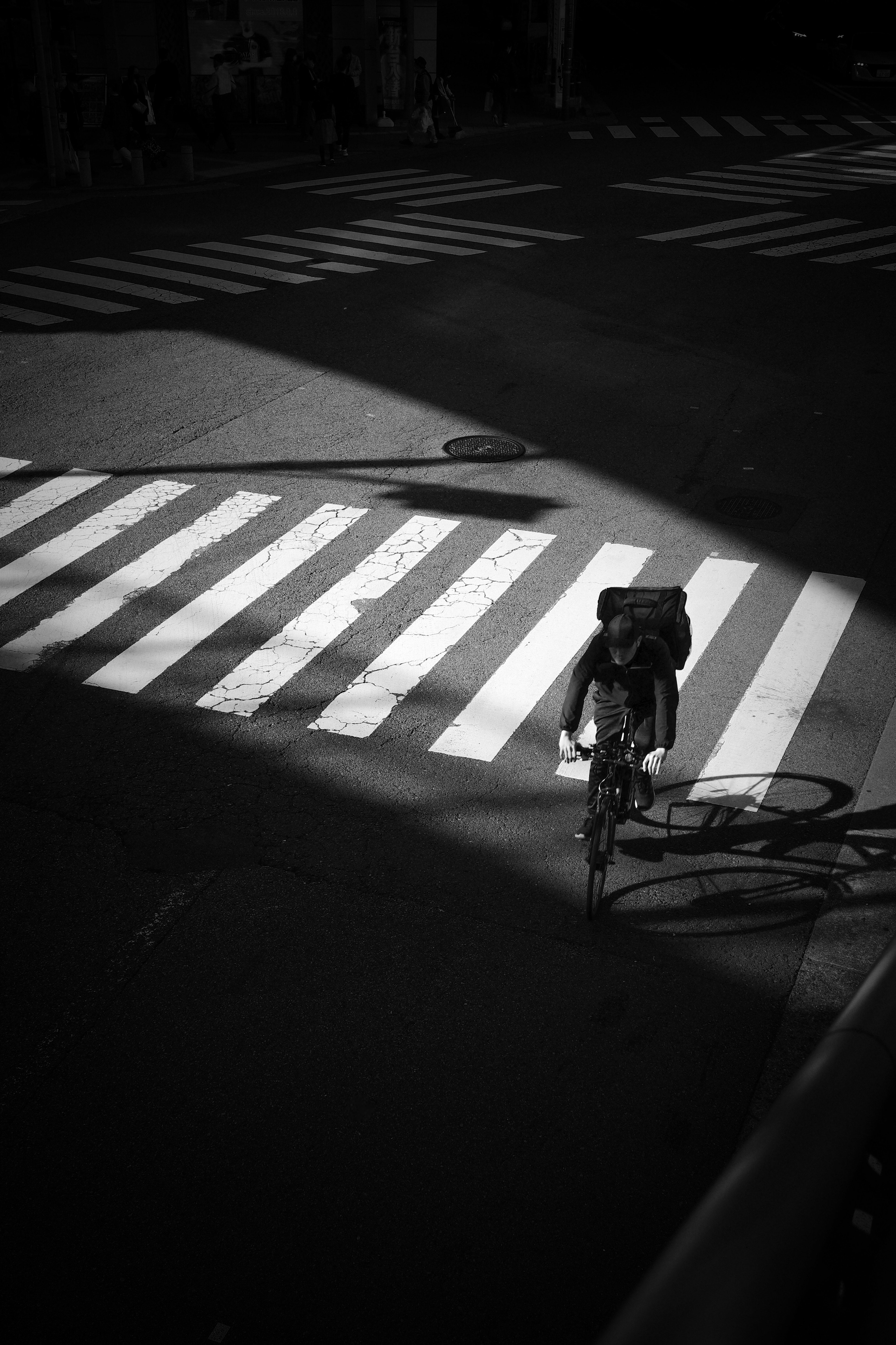 自転車が白黒の横断歩道を渡るシーン