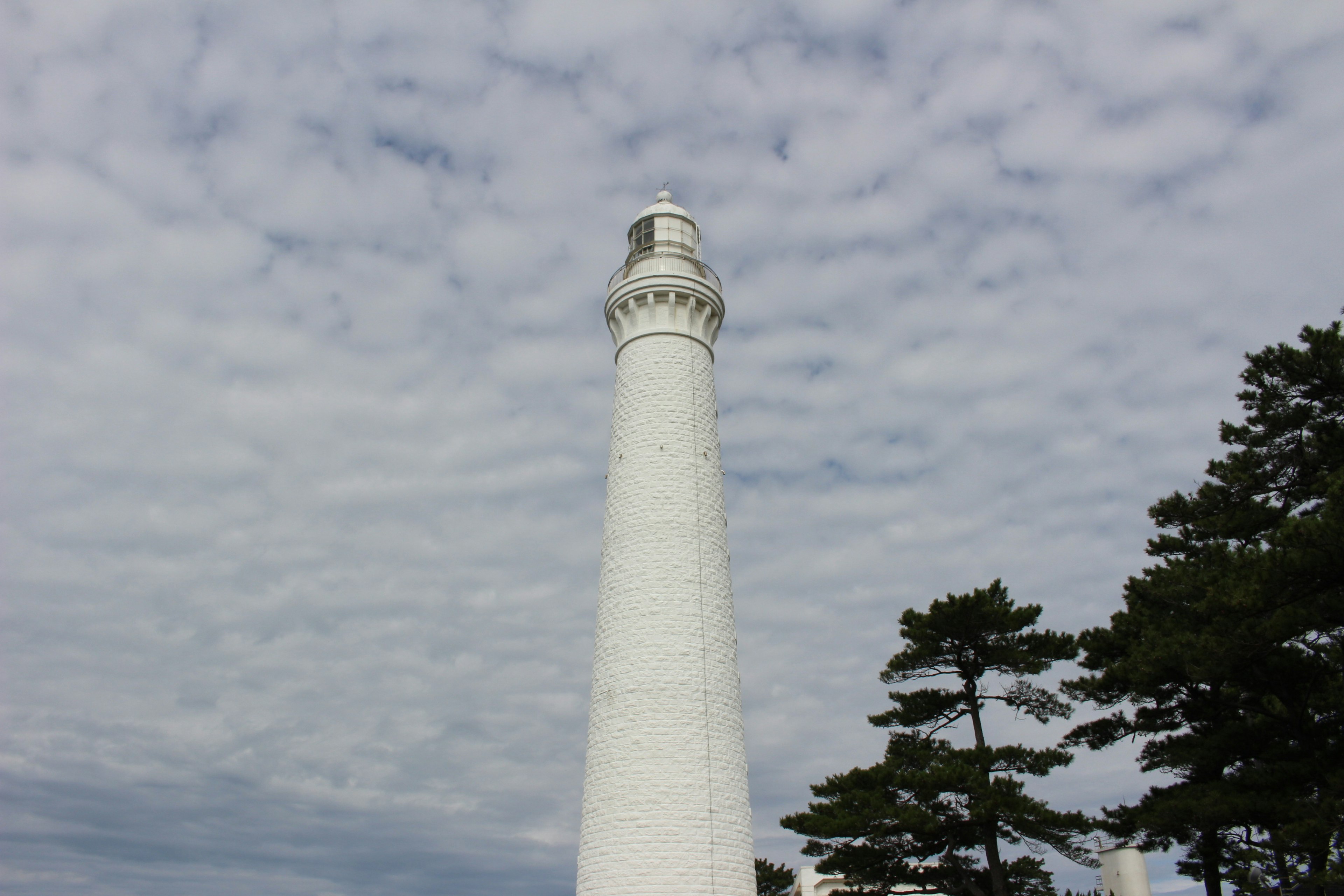 White lighthouse against a cloudy sky