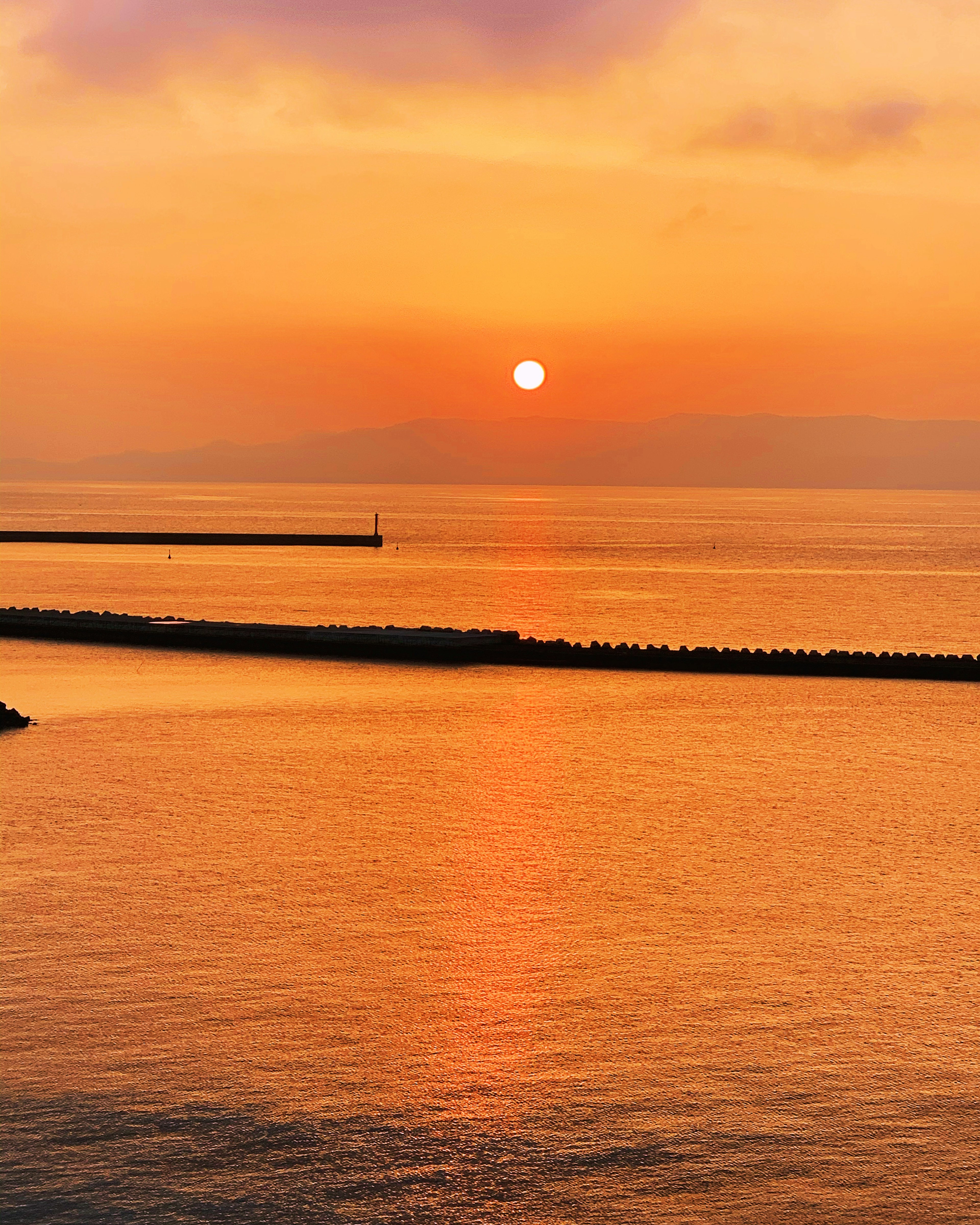 美しい夕日が海に沈む様子と穏やかな水面