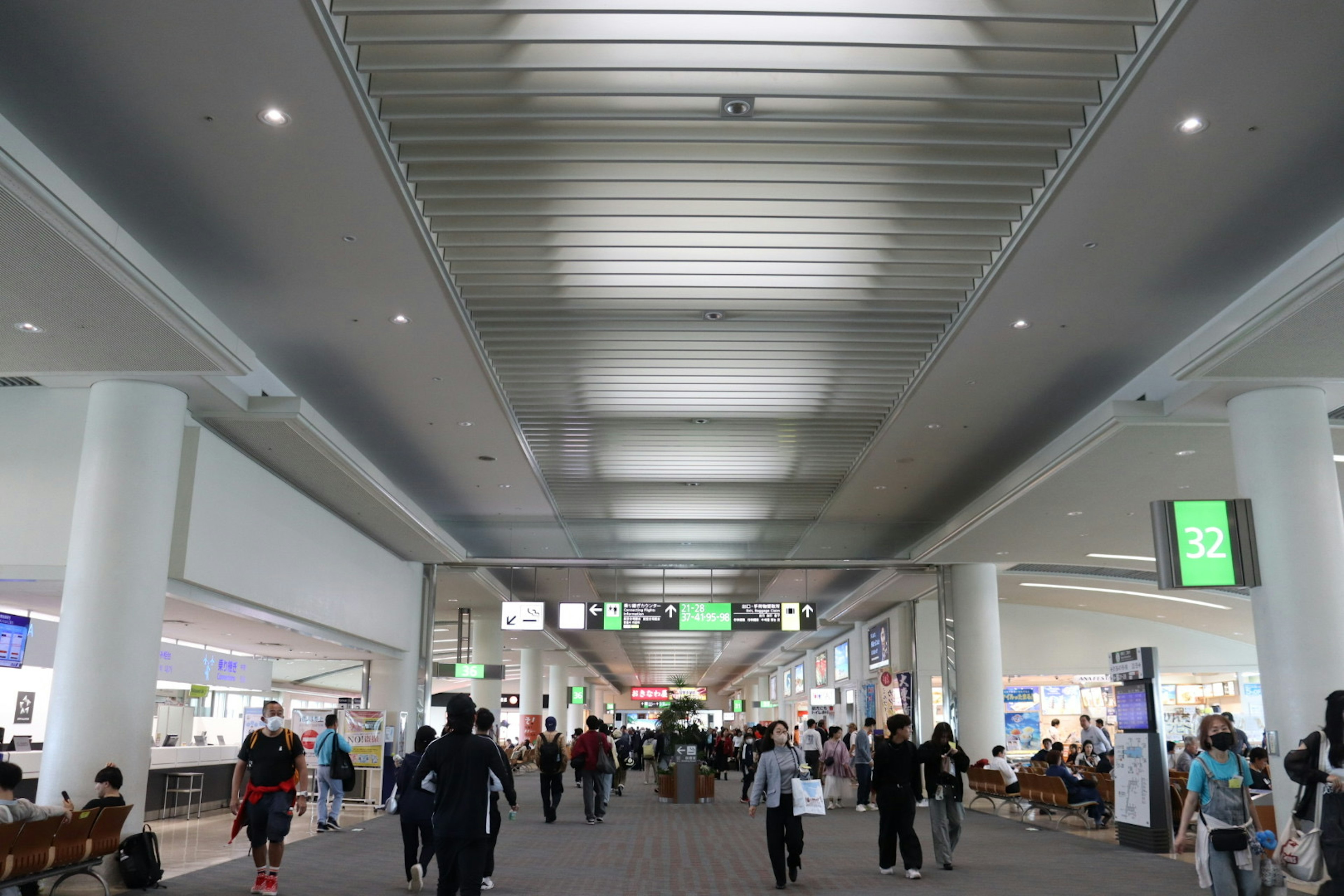 Spacious airport interior with bright ceiling and many people walking