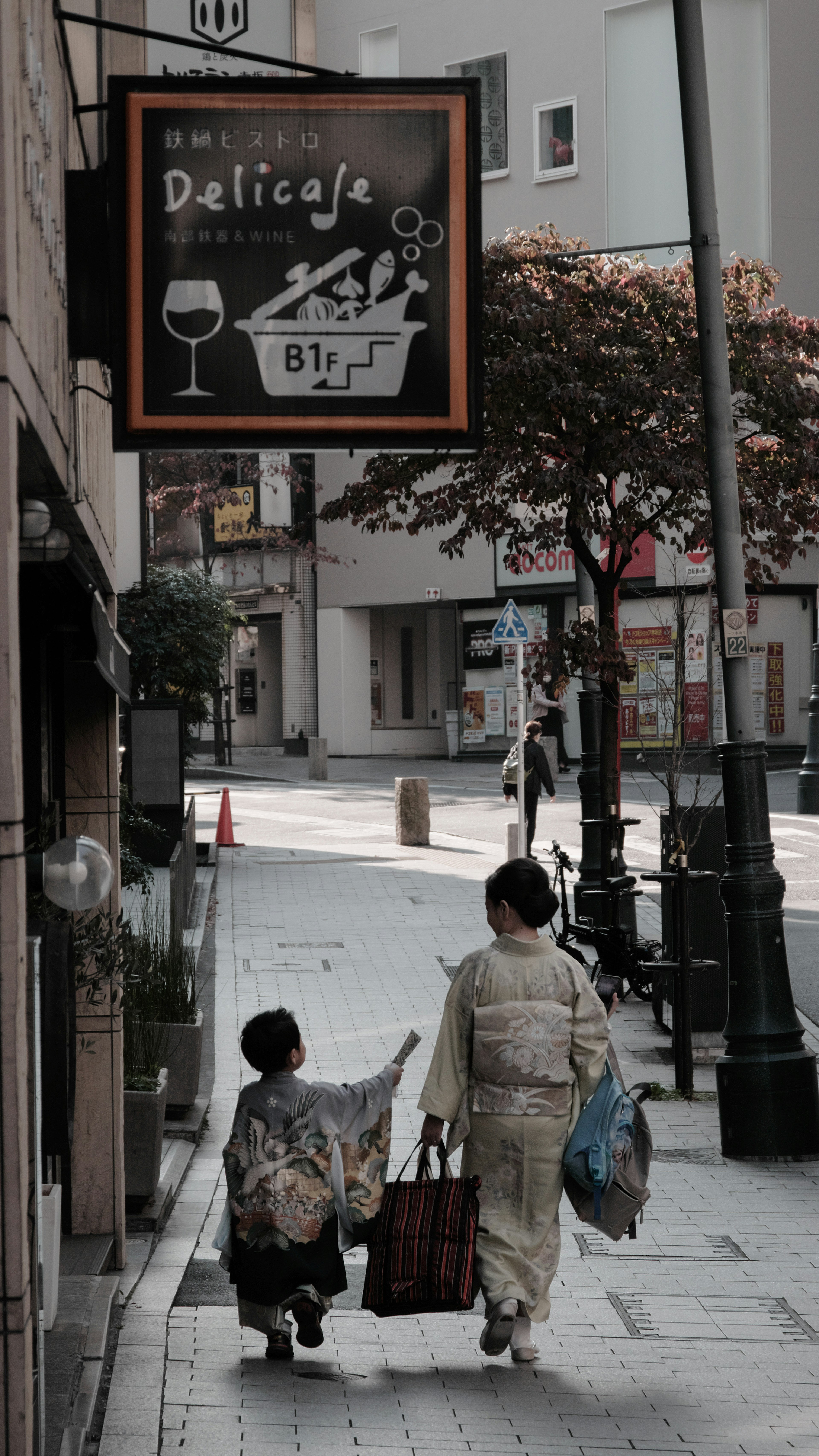 女性と子供が買い物をしながら歩いている街の風景