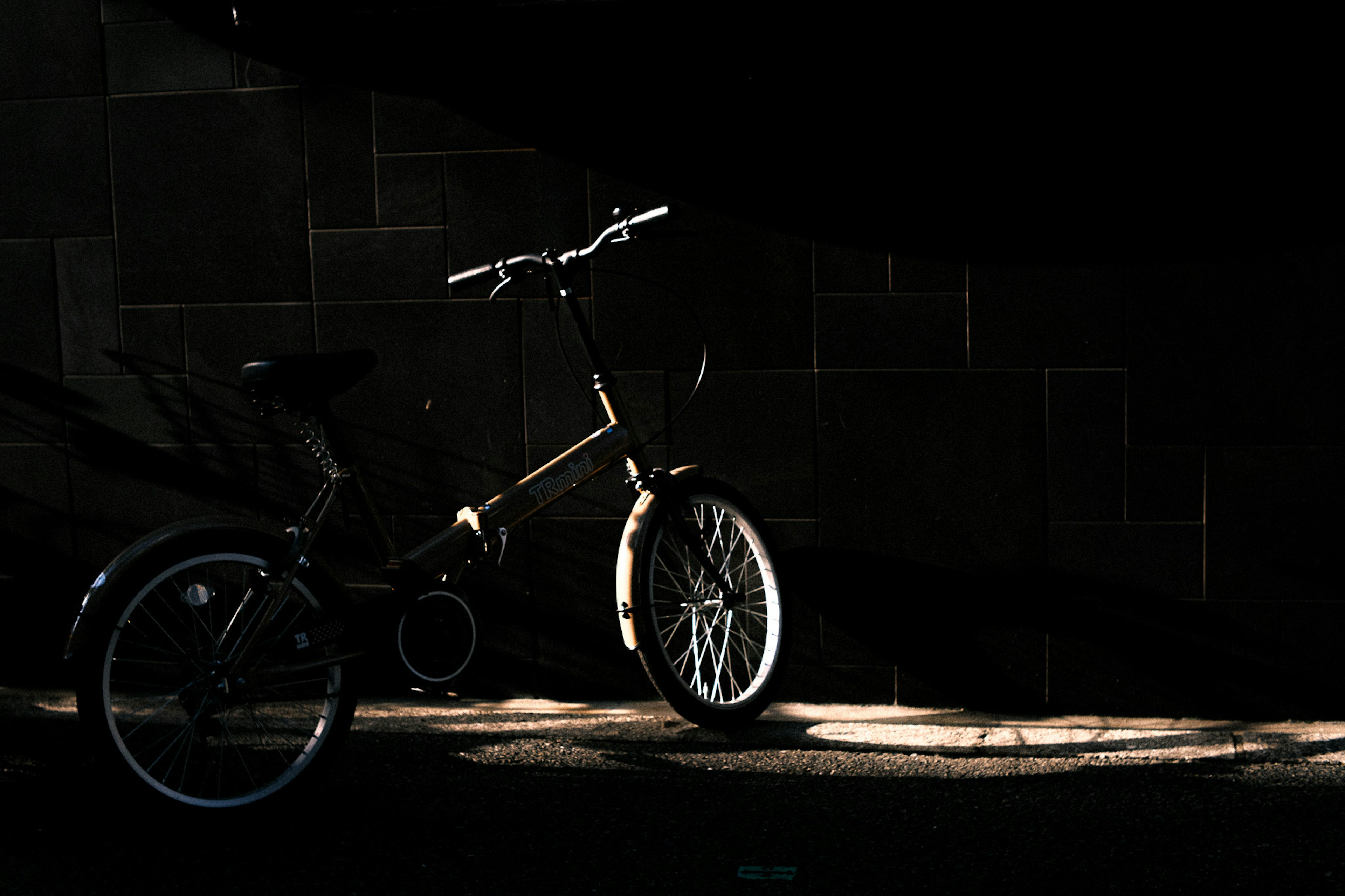 Una bicicletta illuminata dalla luce su uno sfondo scuro