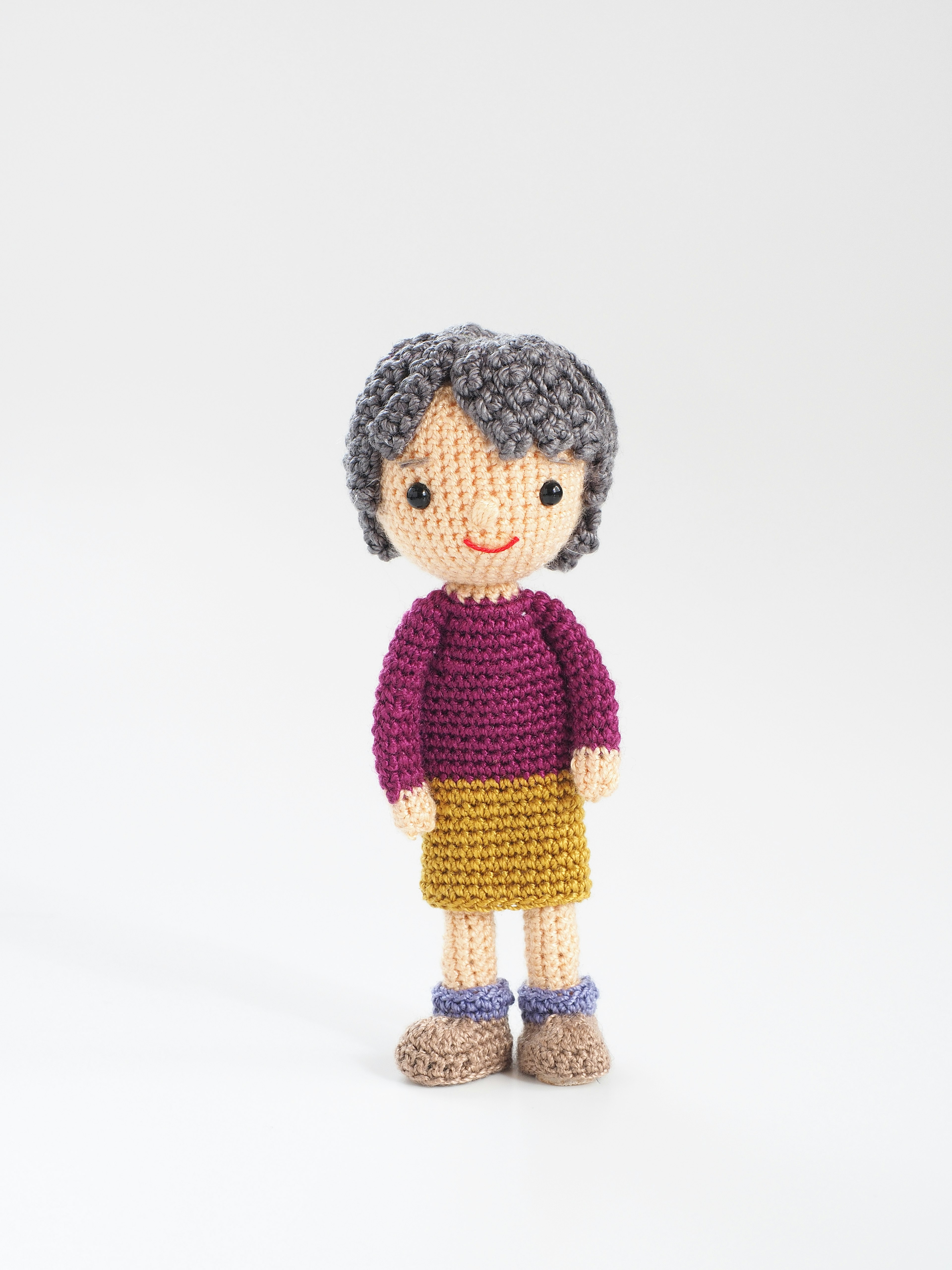 Handmade amigurumi doll of a girl with bright colored clothing and short hair