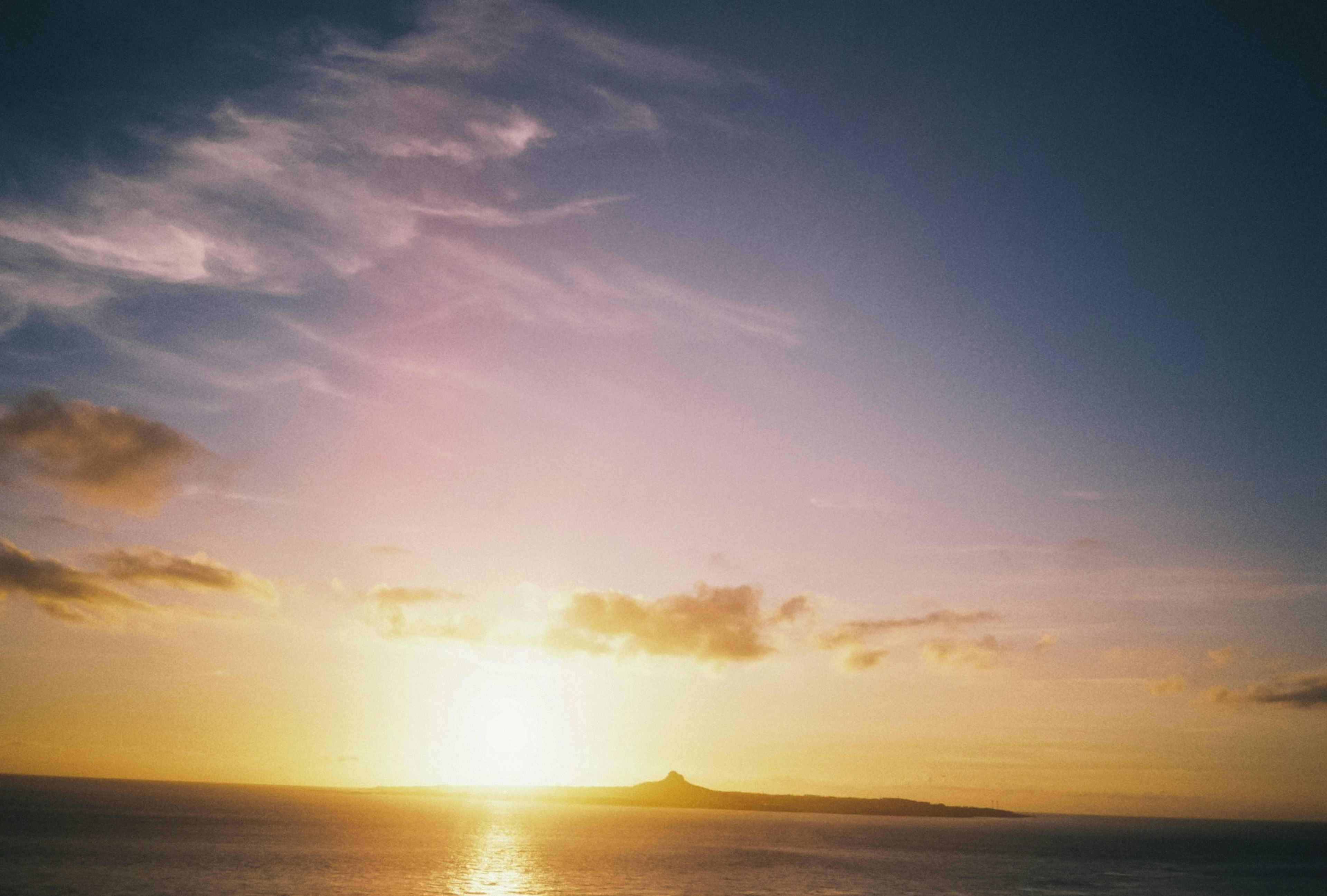 夕日が海に沈む美しい風景に、遠くの島が見える