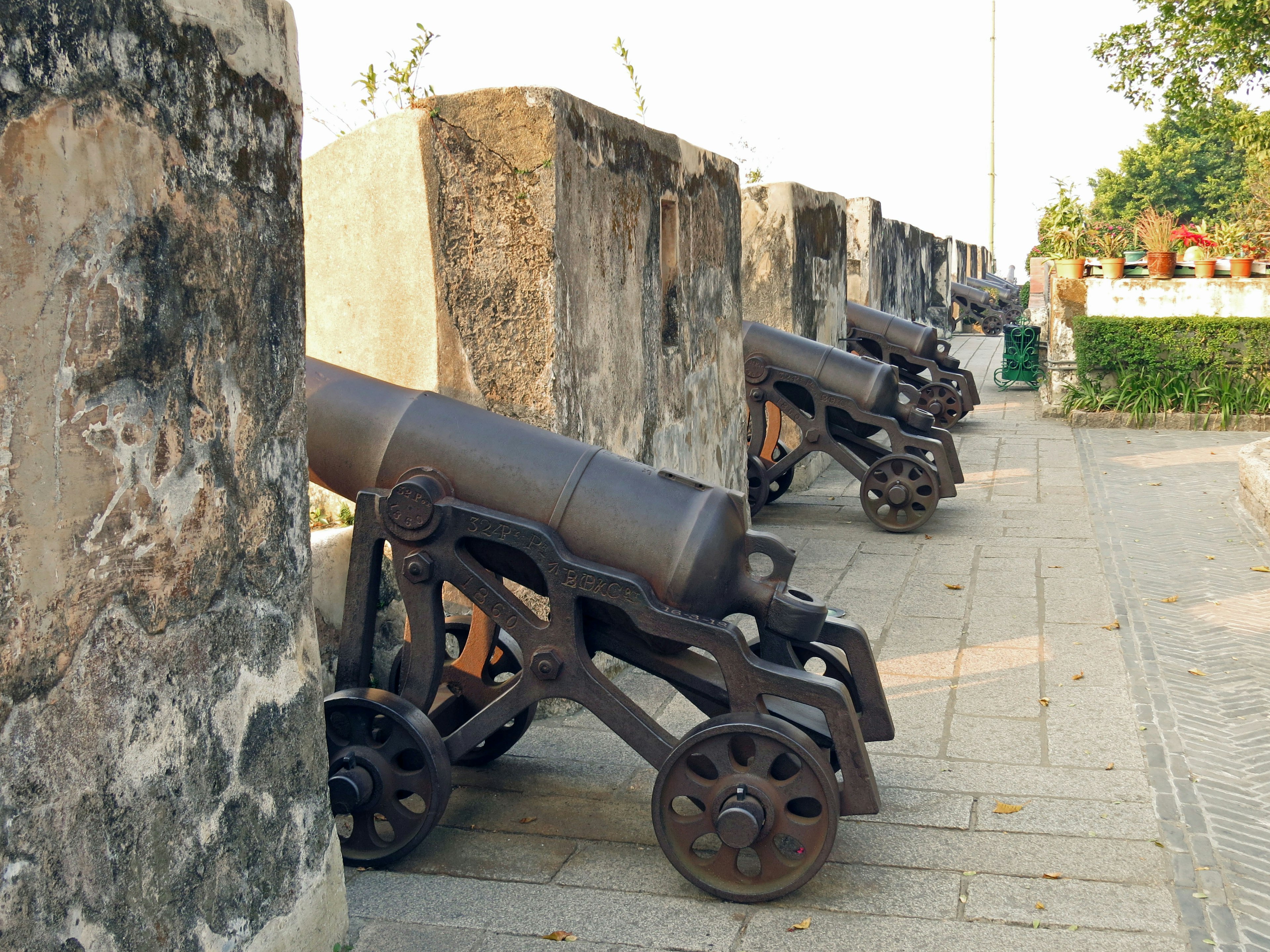 Rangée de canons historiques près de murs en pierre