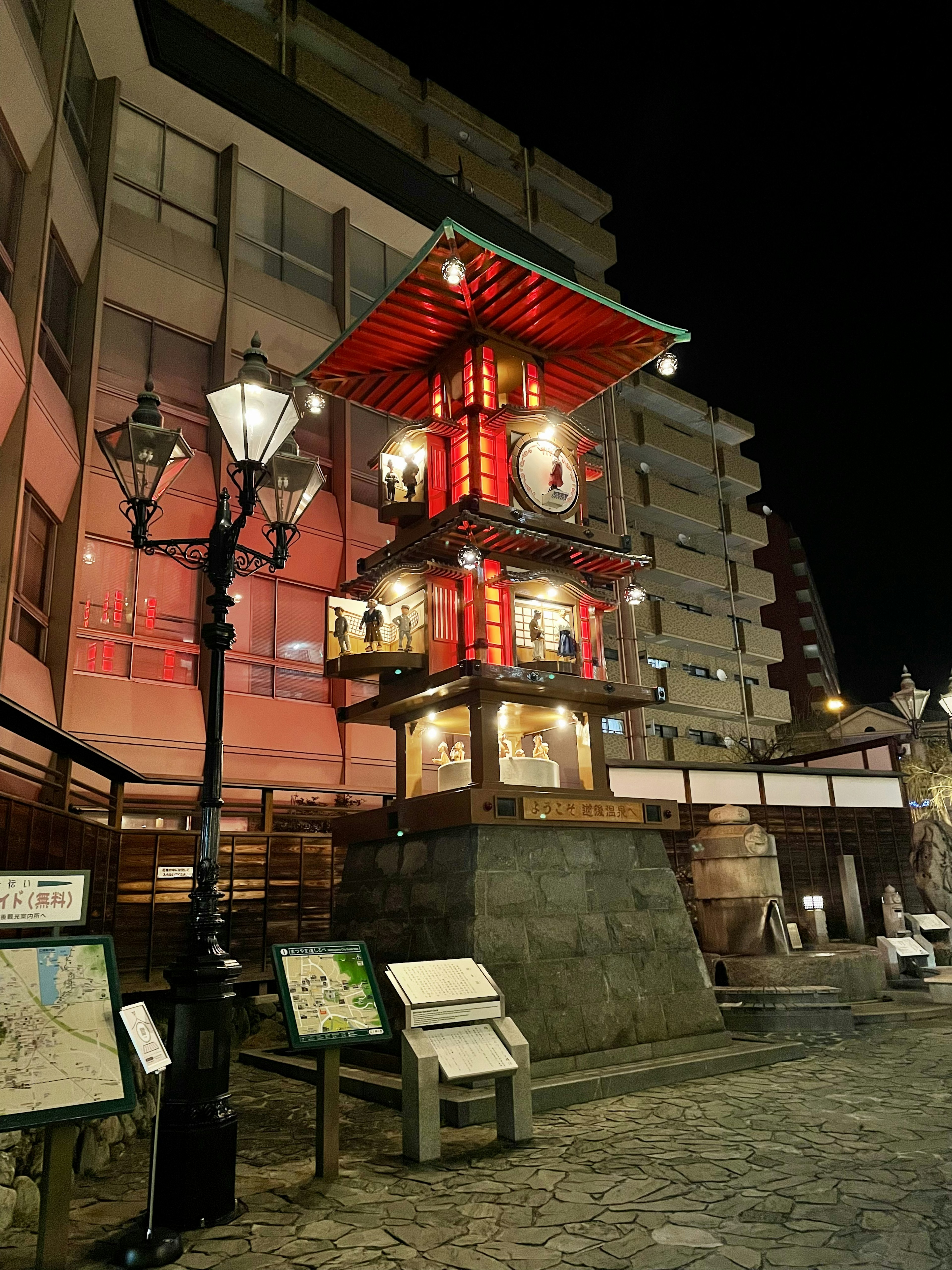 Una struttura a forma di pagoda rossa illuminata di notte con lampioni vintage