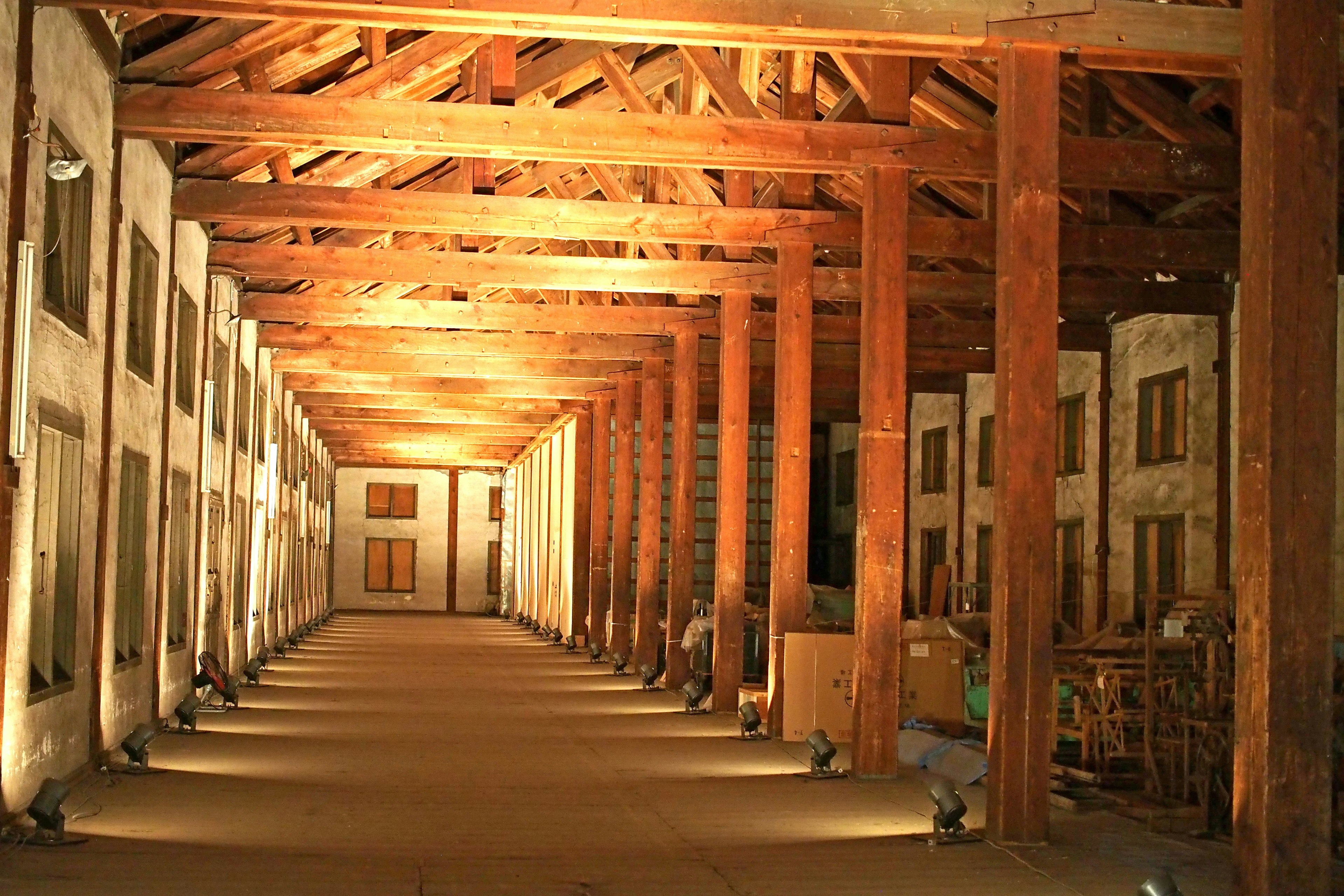 A spacious interior featuring wooden beams and columns