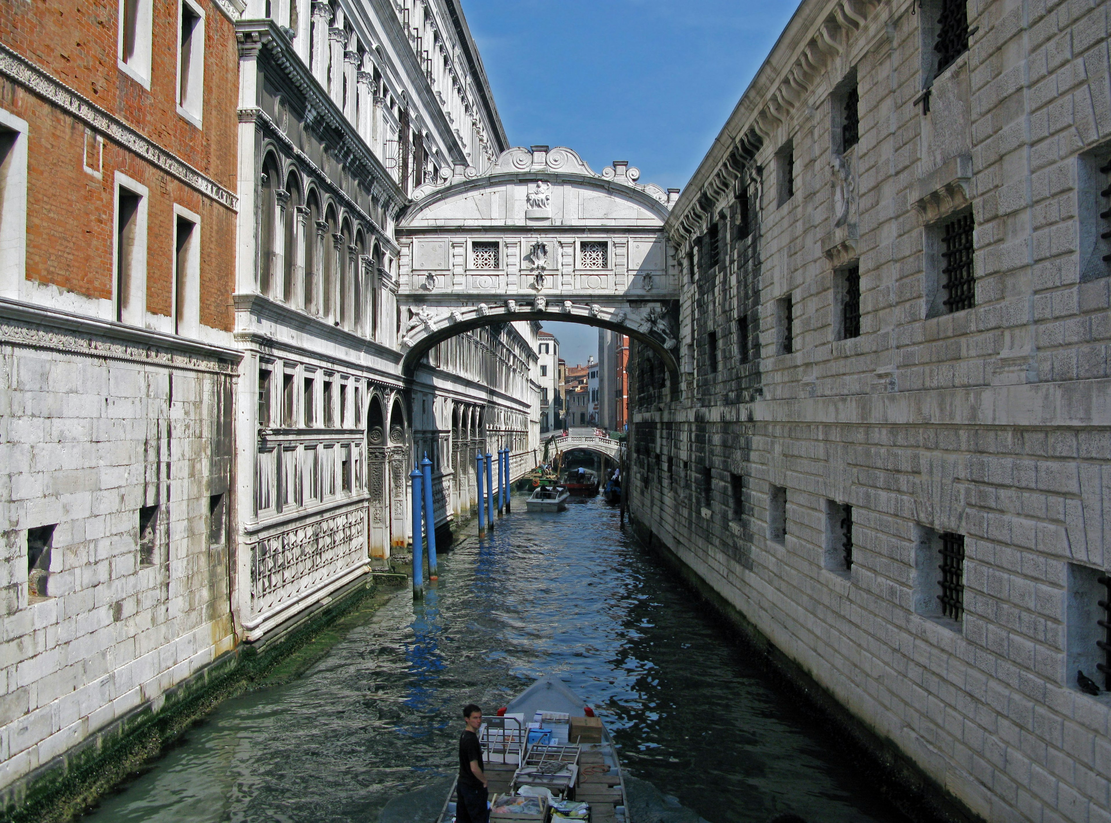 Khung cảnh một kênh ở Venice với các tòa nhà lịch sử và một cây cầu dưới bầu trời xanh