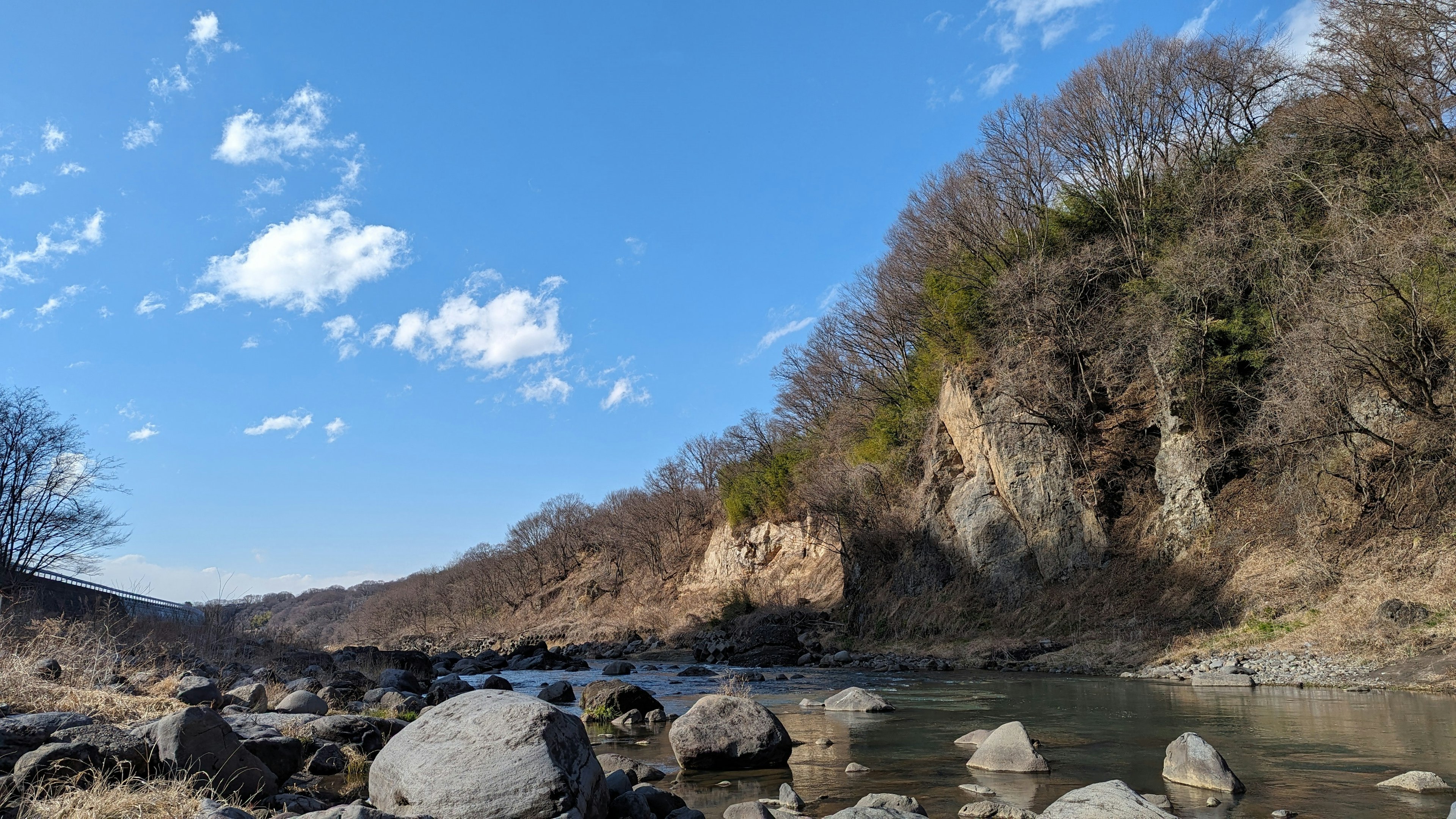 Vue pittoresque d'une rivière et de rochers sous un ciel bleu avec des nuages blancs