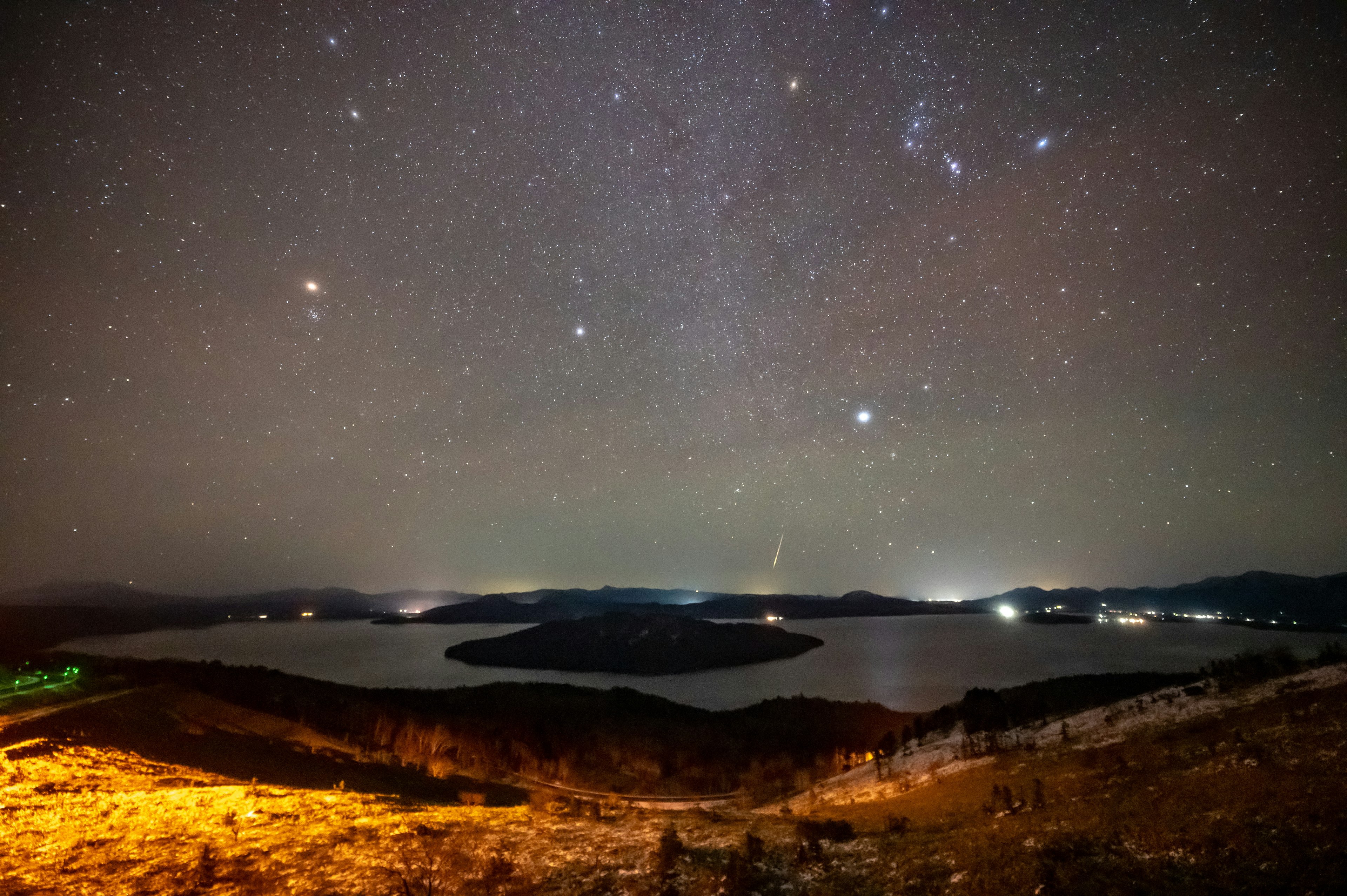 Night sky with stars and a lake scenic view featuring bright stars and a tranquil lake