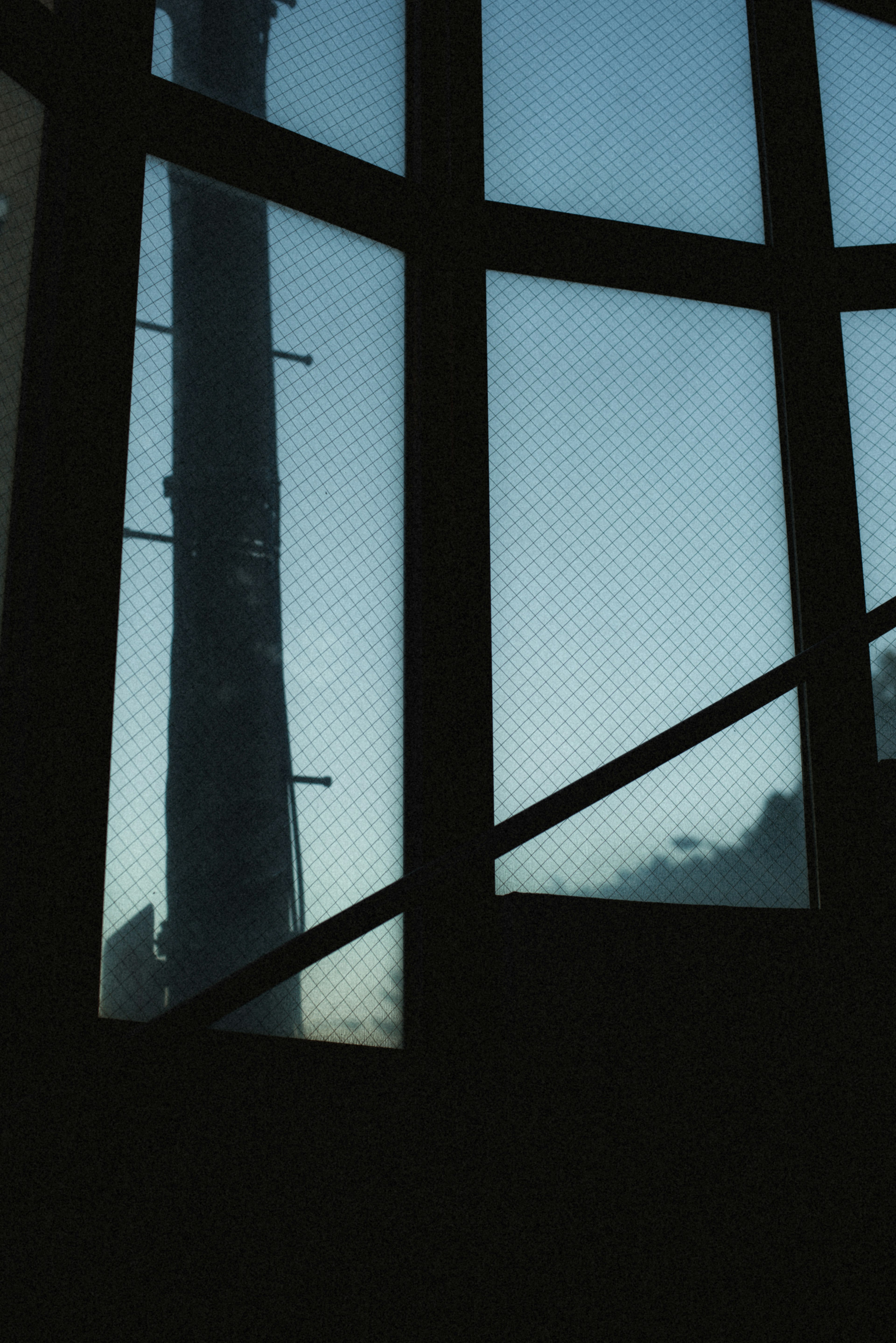 Silhouette of a tower and blue sky visible through a window