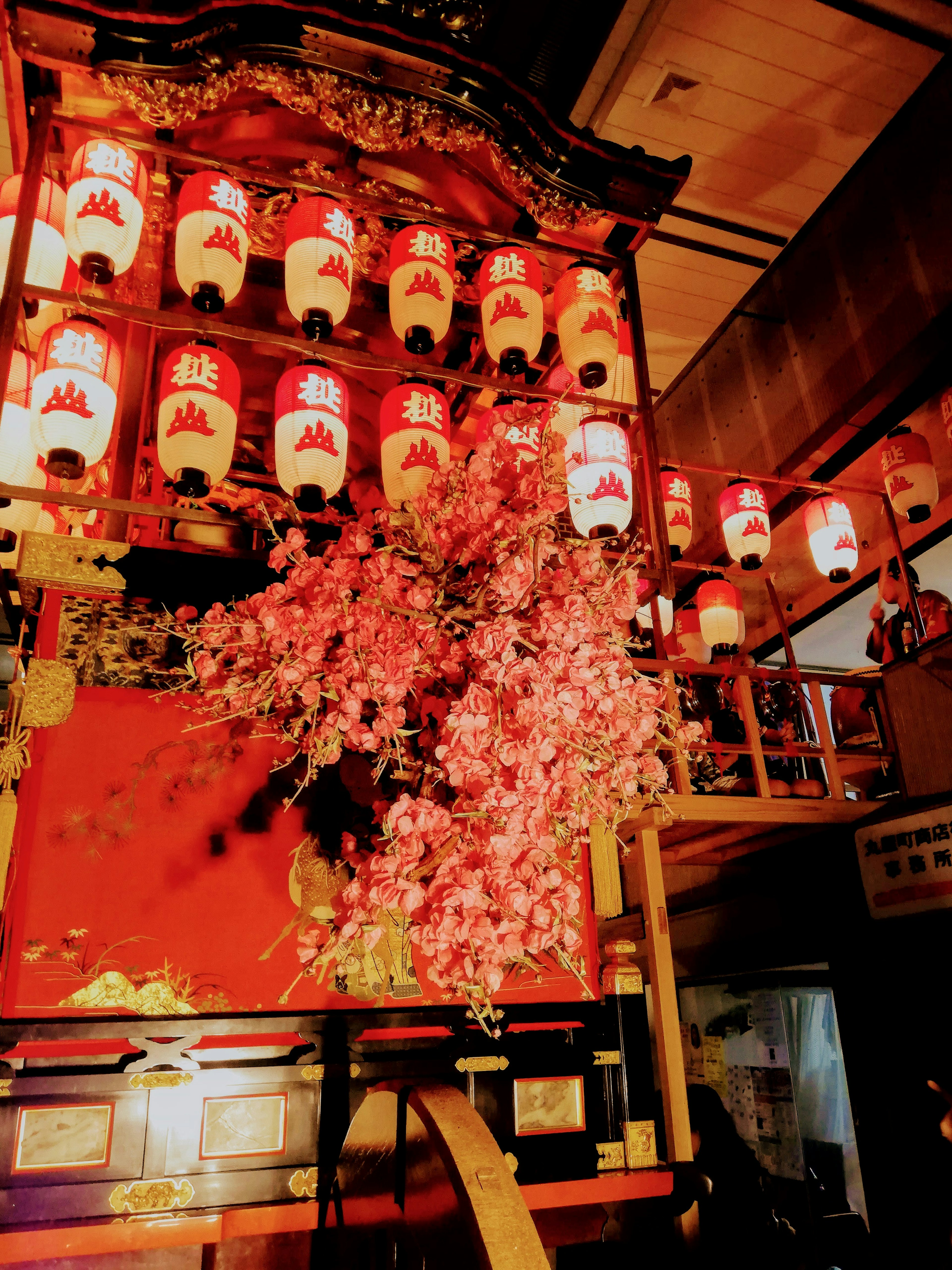 Carro decorado en rojo con linternas colgantes y flores de cerezo