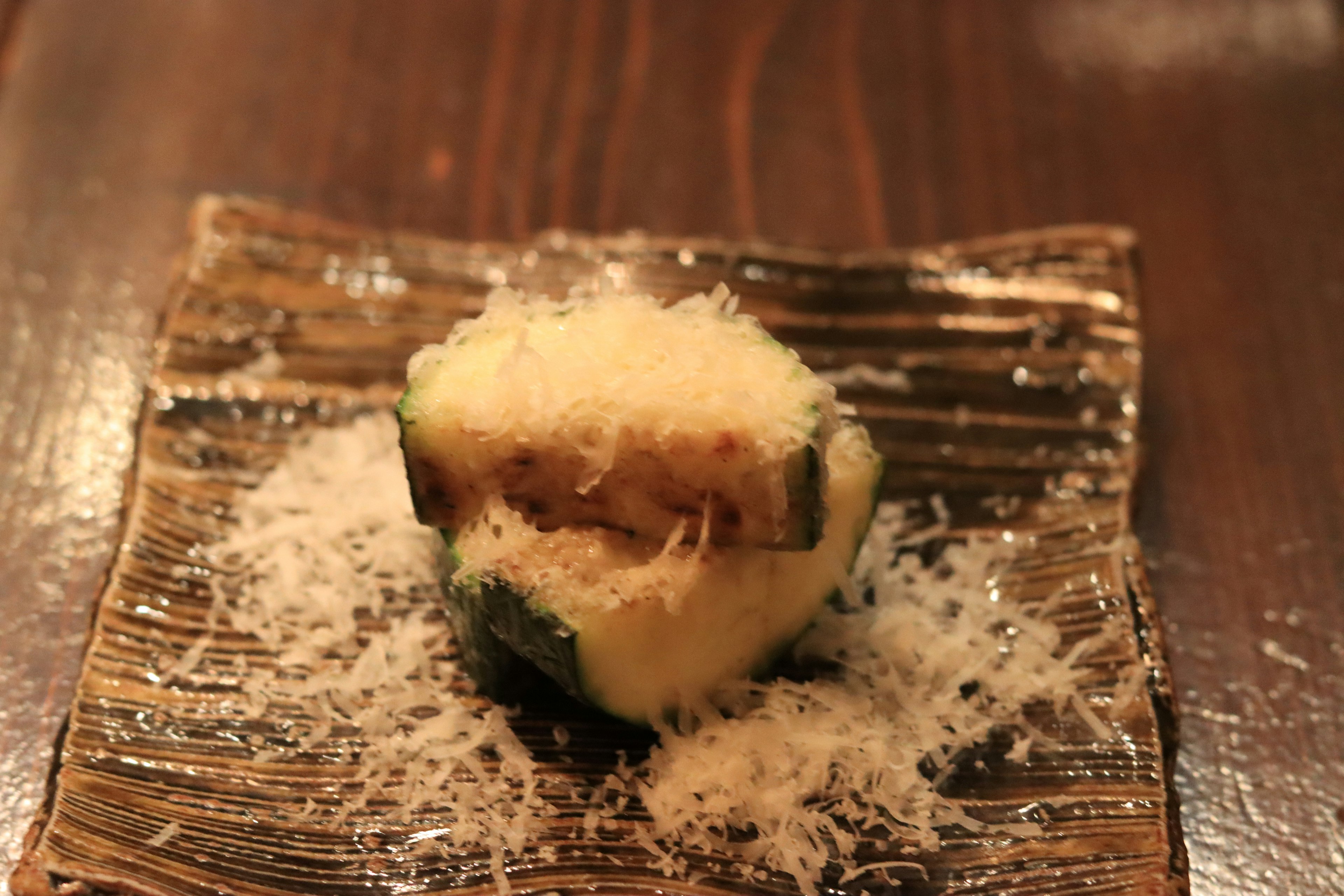 Un piatto con formaggio e verdure su un piatto testurizzato