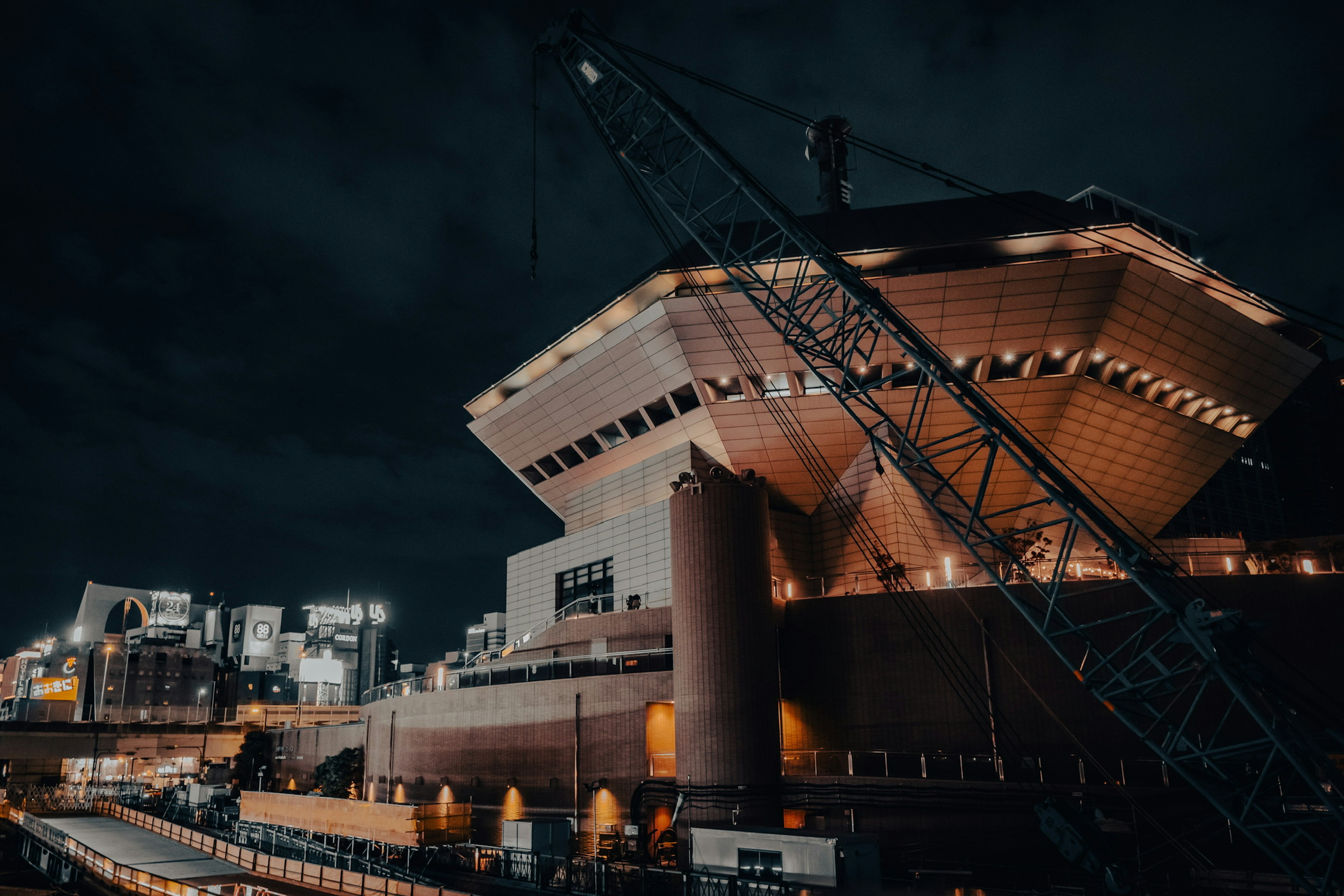 Bâtiment moderne et grue la nuit dans un port