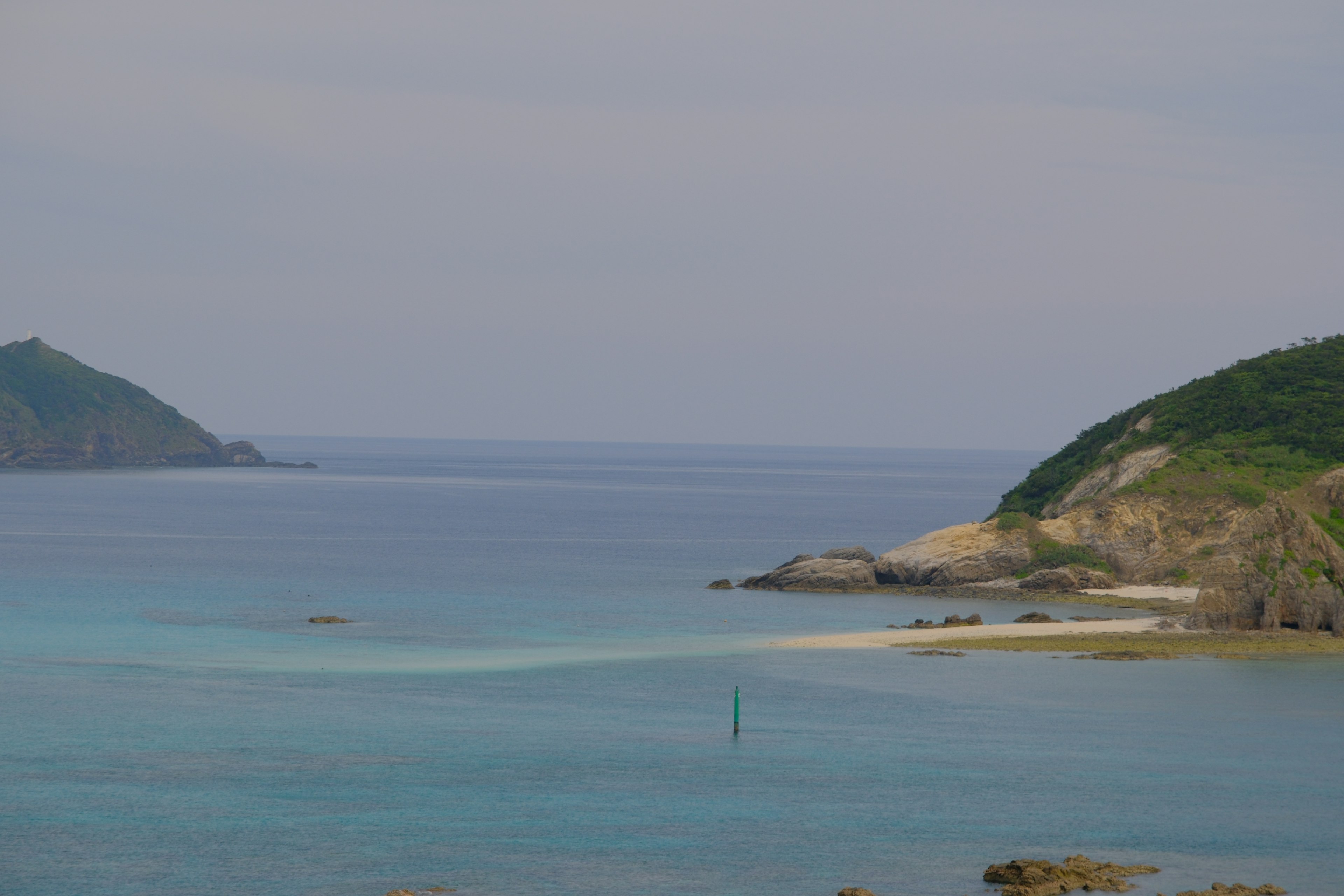 平靜的海面與背景中的綠色山丘