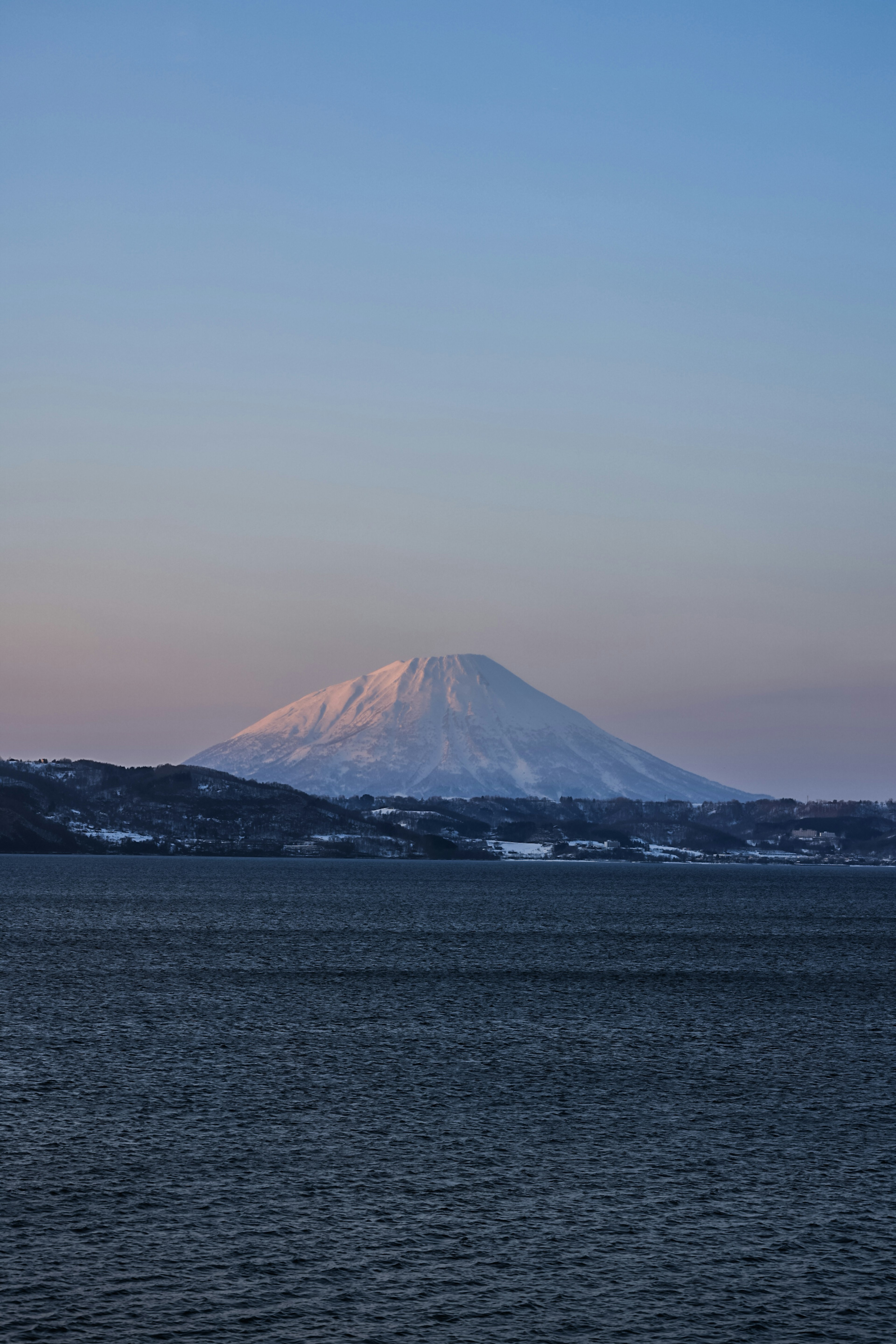 雪をかぶった山と穏やかな湖の景色