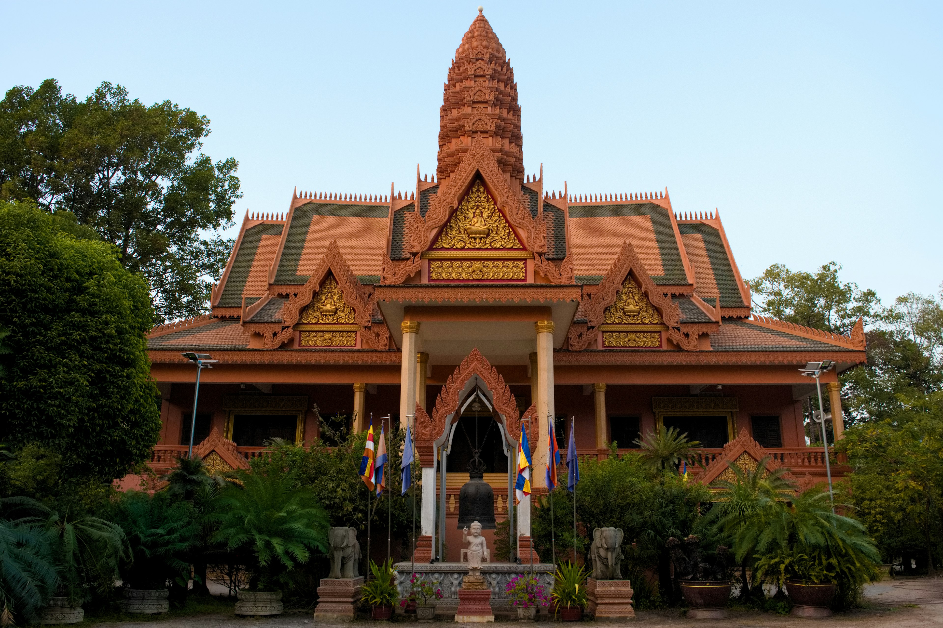 Facciata di un tempio cambogiano tradizionale circondata da vegetazione lussureggiante