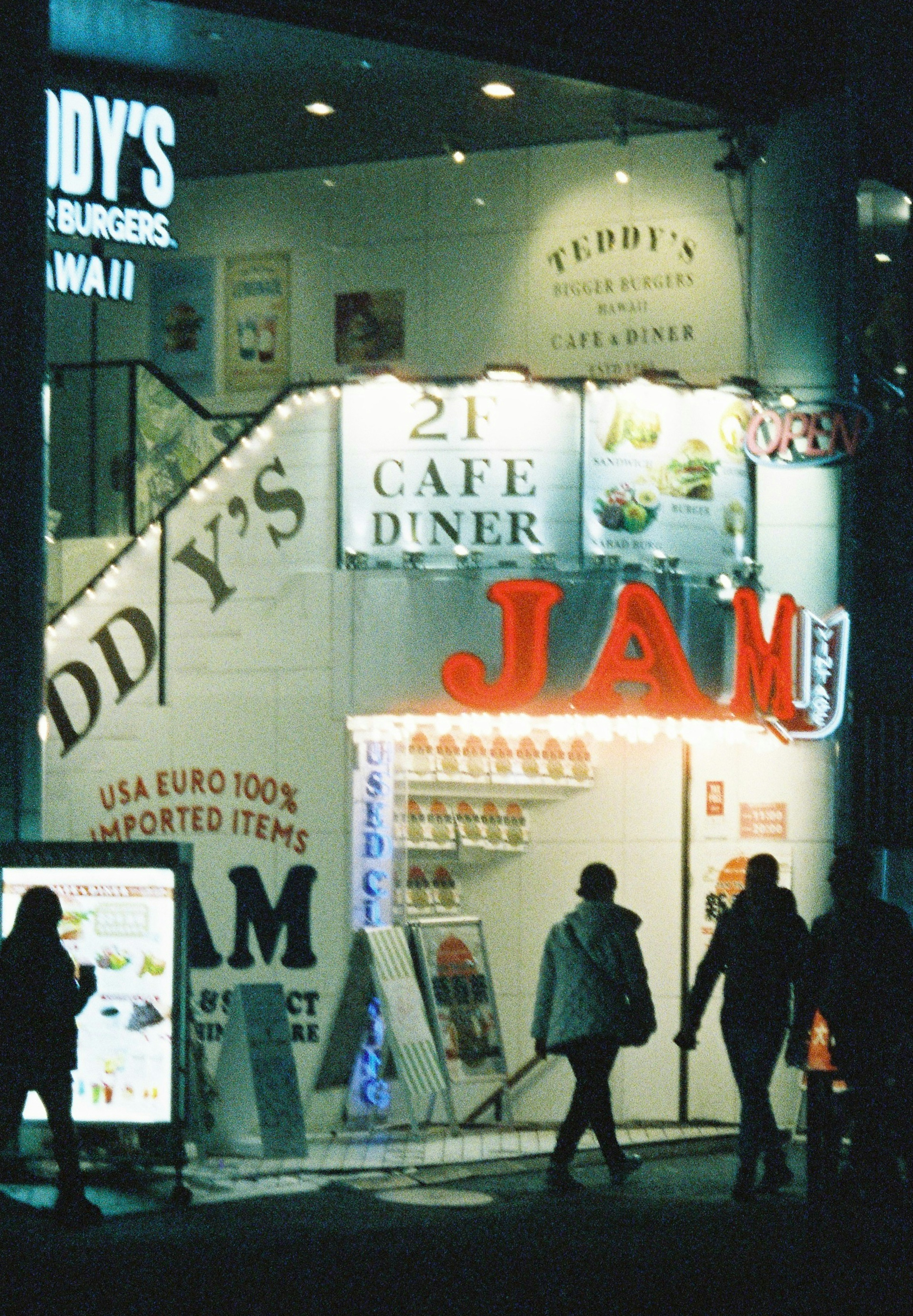 夜间行人和Eddy's Cafe Diner发光招牌