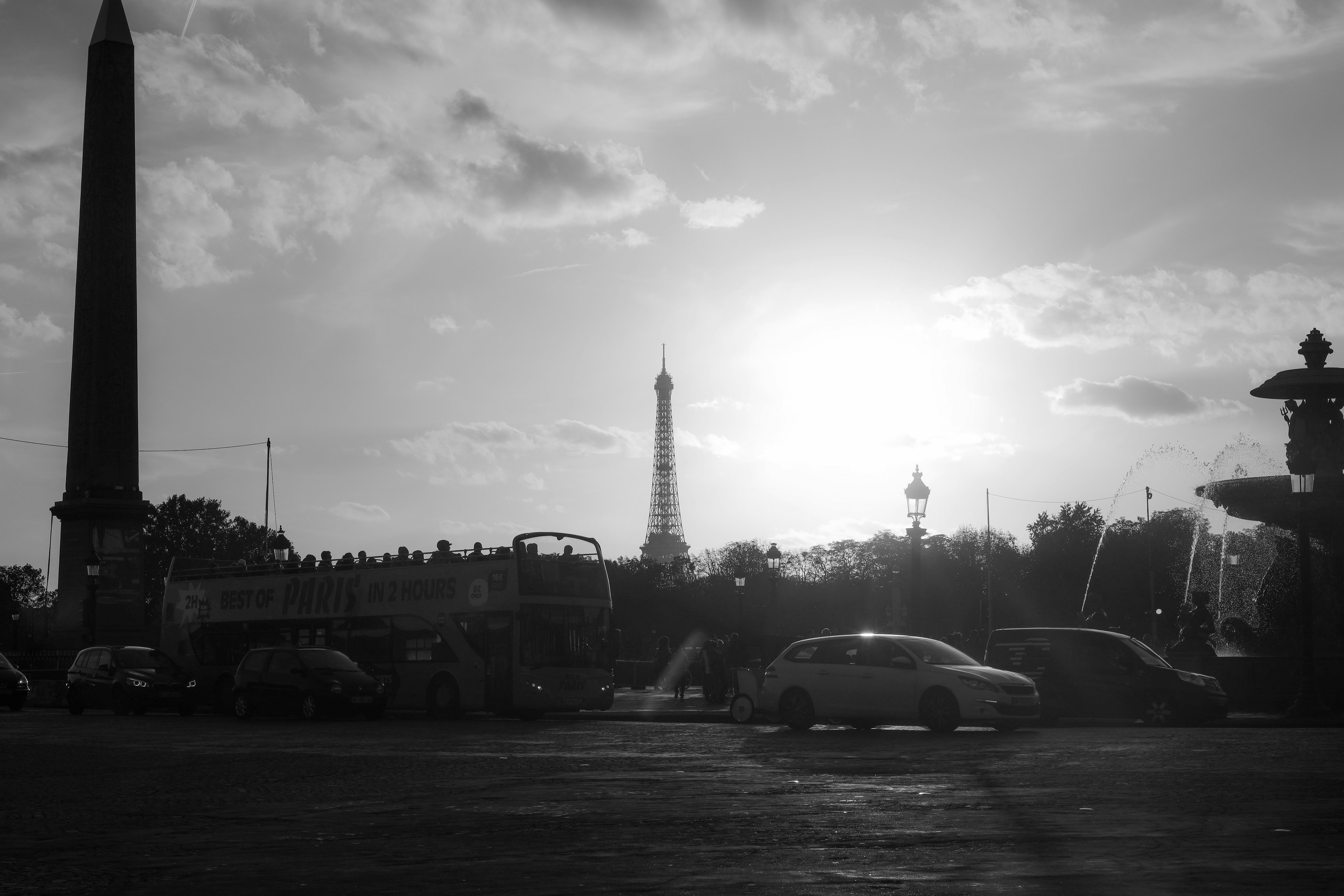 Silhouette of the Eiffel Tower and obelisk against a sunset in black and white