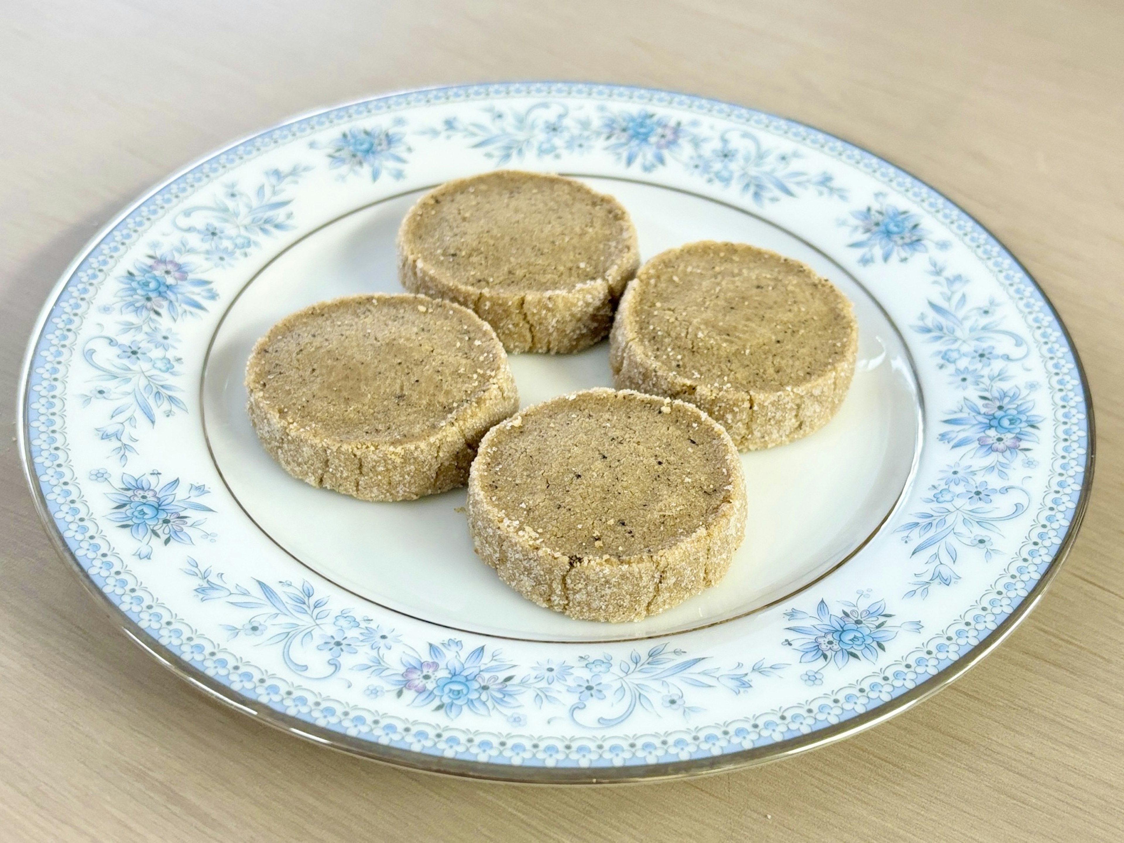 Four round cookies arranged on a decorative white plate