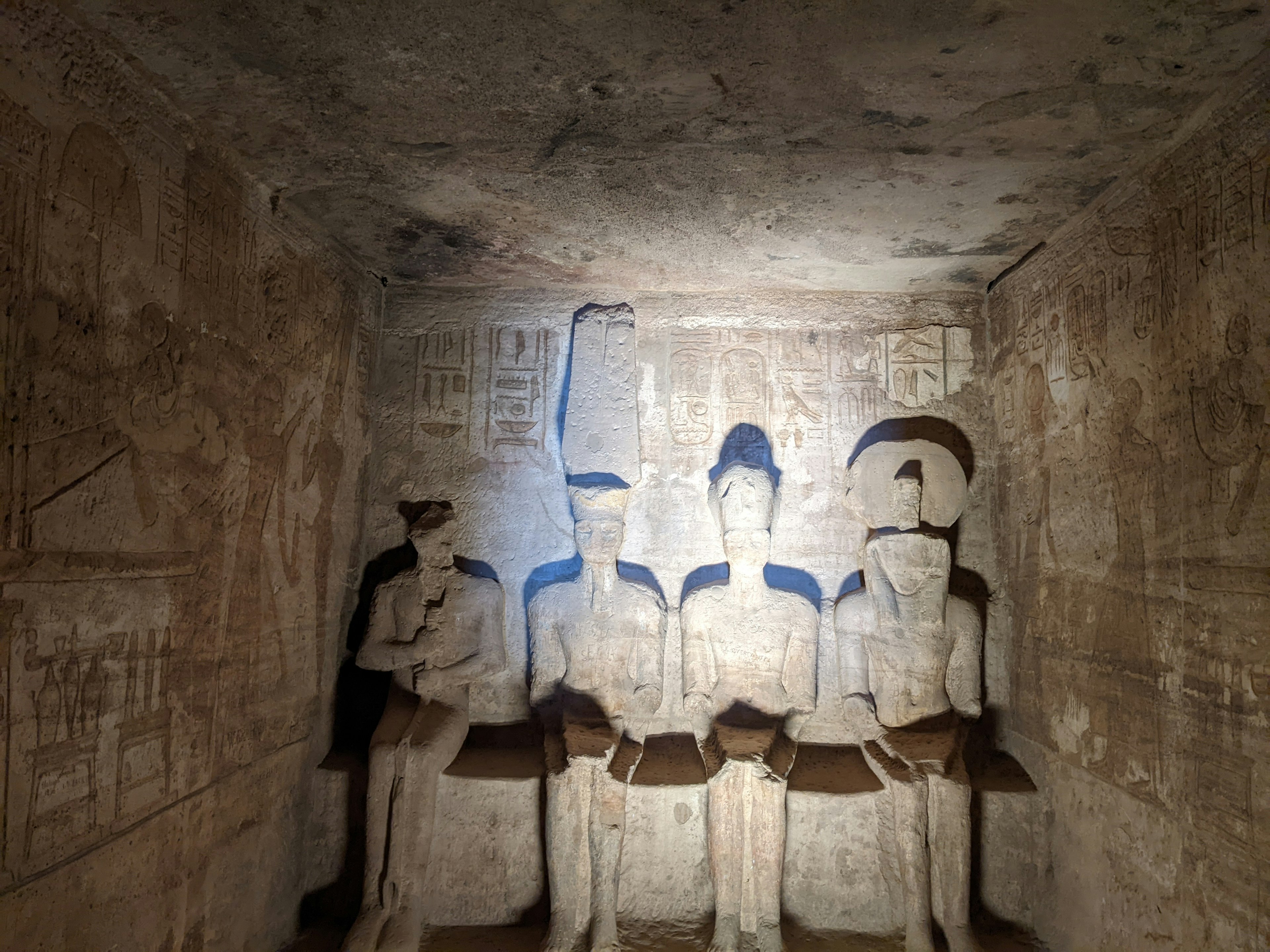 Interior de una cueva antigua con tres estatuas de pie