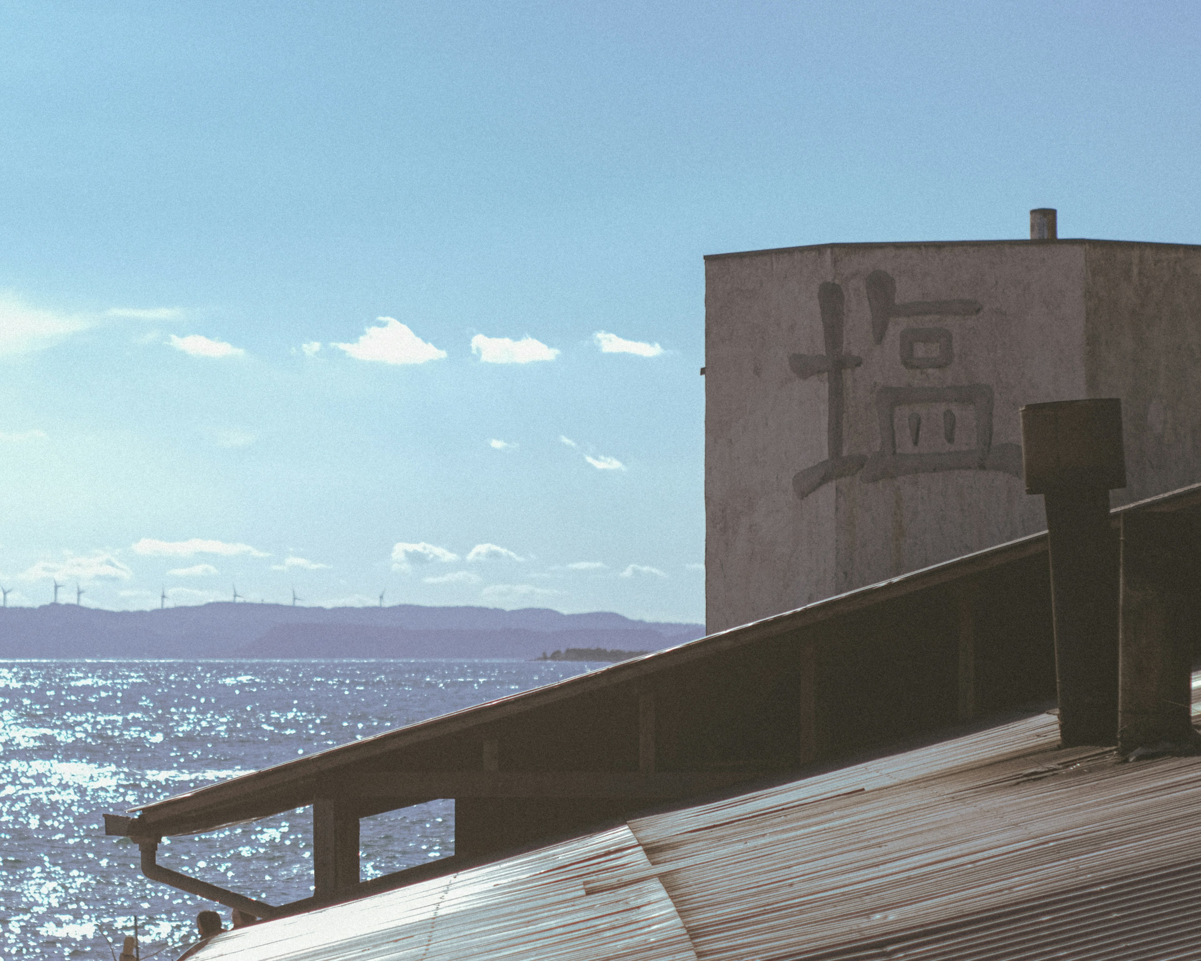 Side of a building with salt characters overlooking the sea