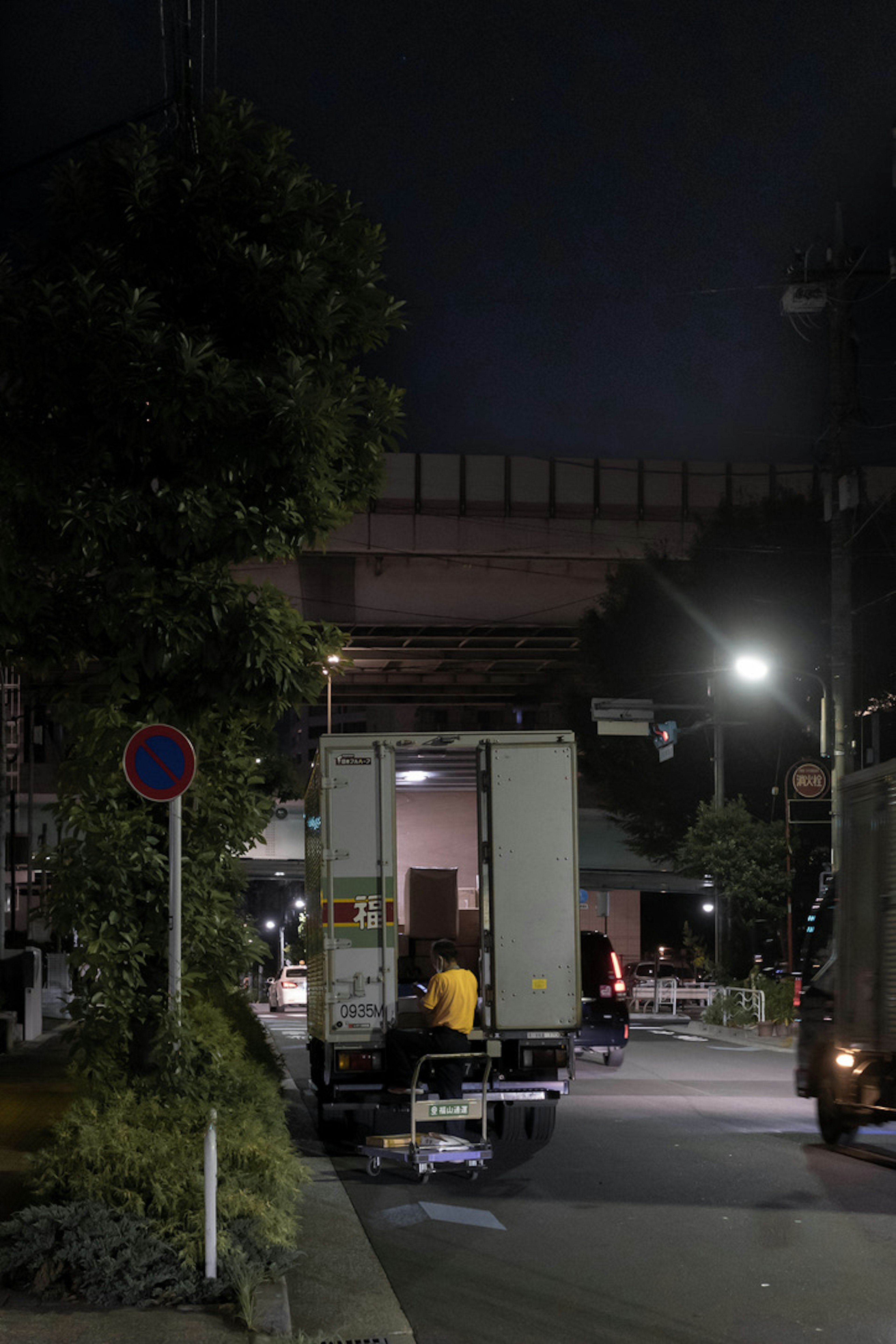 Sebuah truk memuat barang di kota pada malam hari