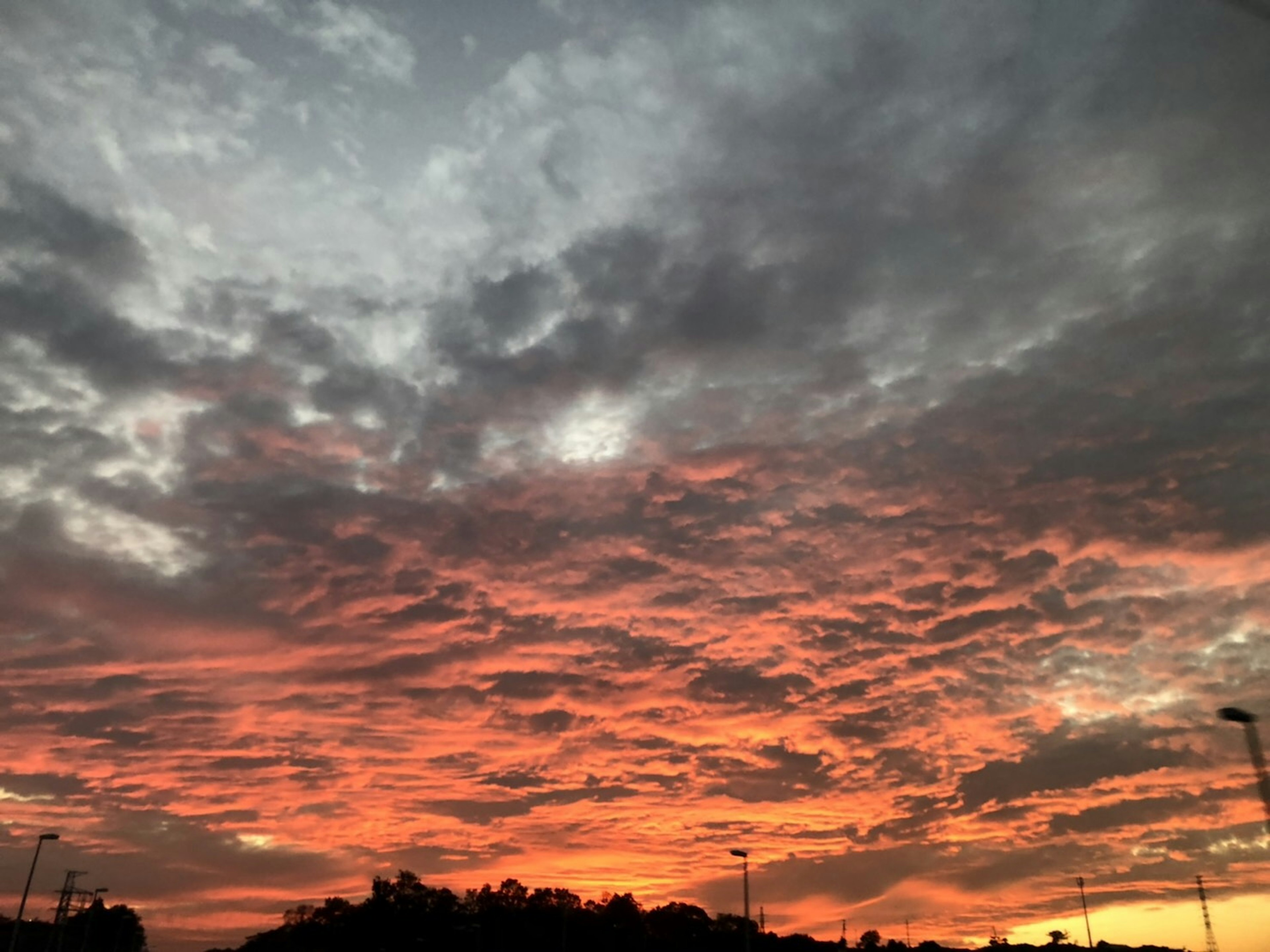 Tramonto drammatico con nuvole arancioni e grigie nel cielo